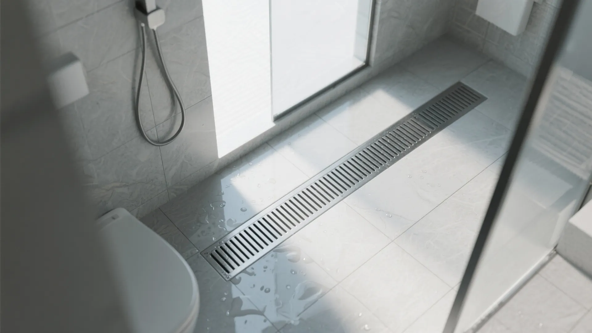 Modern bathroom shower area with grey floor tiles and a long metal floor water drain