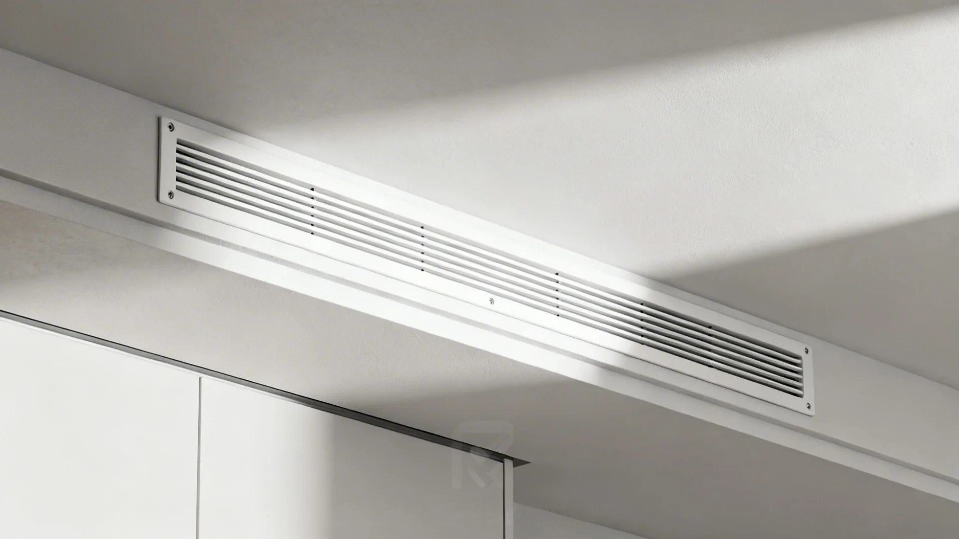 Macro of matte white linear slot diffuser with crisp reveal and aligned access line.