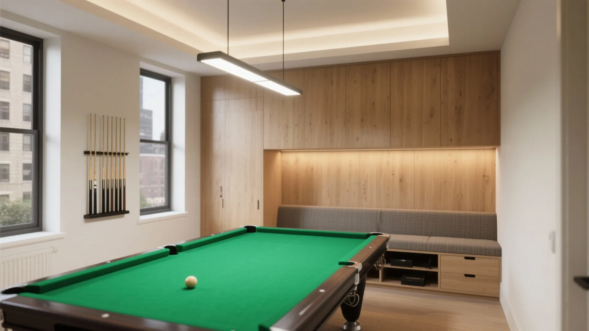 Indoor pool table room with wood wall cabinets a grey bench seat and light fixture