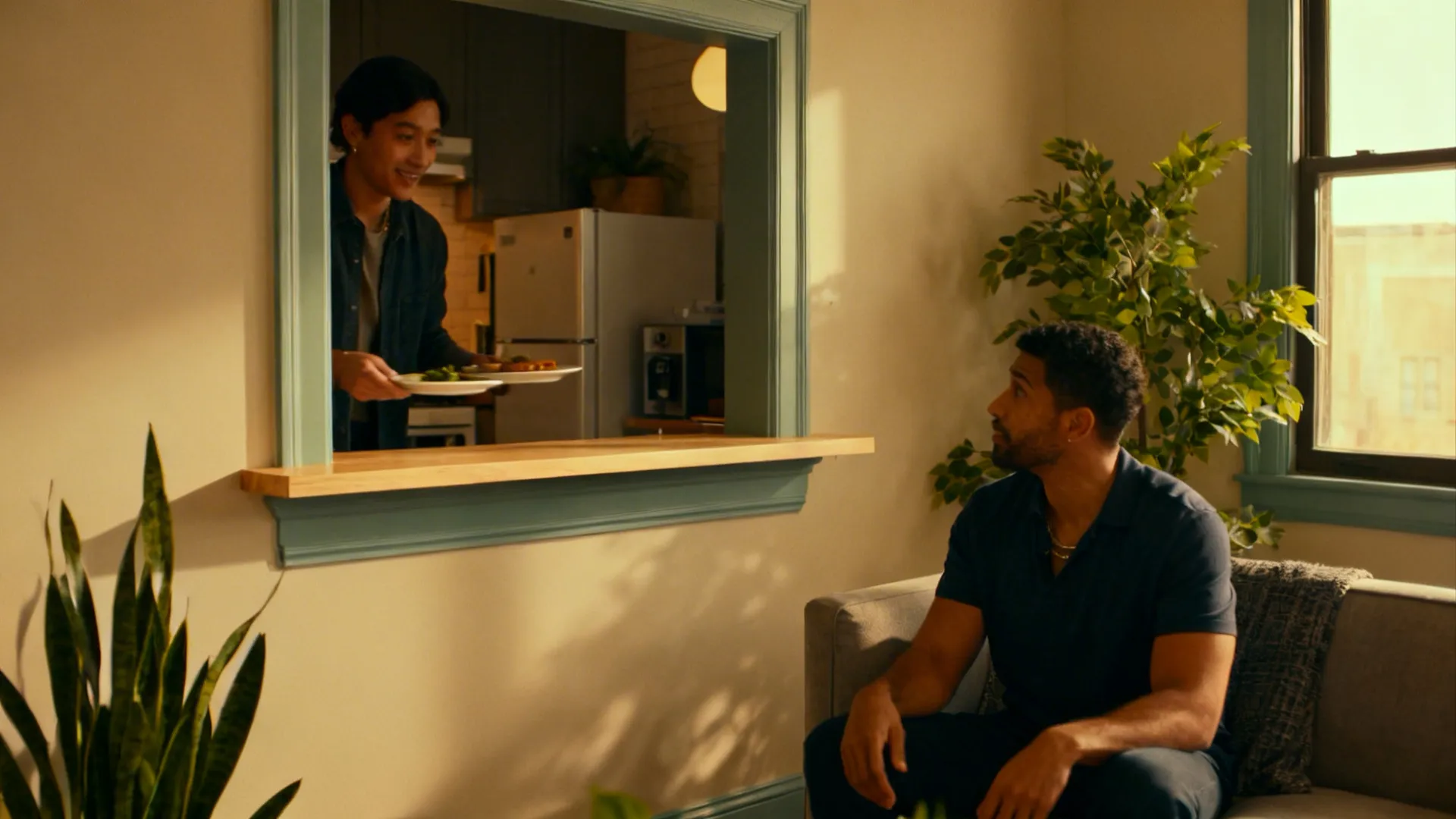 Studio apartment showing a serving ledge pass-through window with people interacting across it.