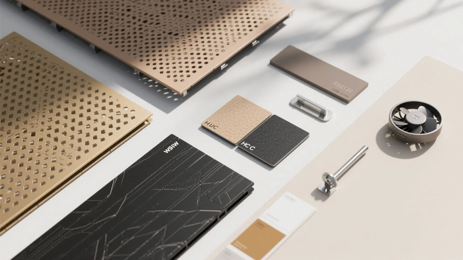 Interior design material samples including perforated metal plates color swatches and small hardware parts collection