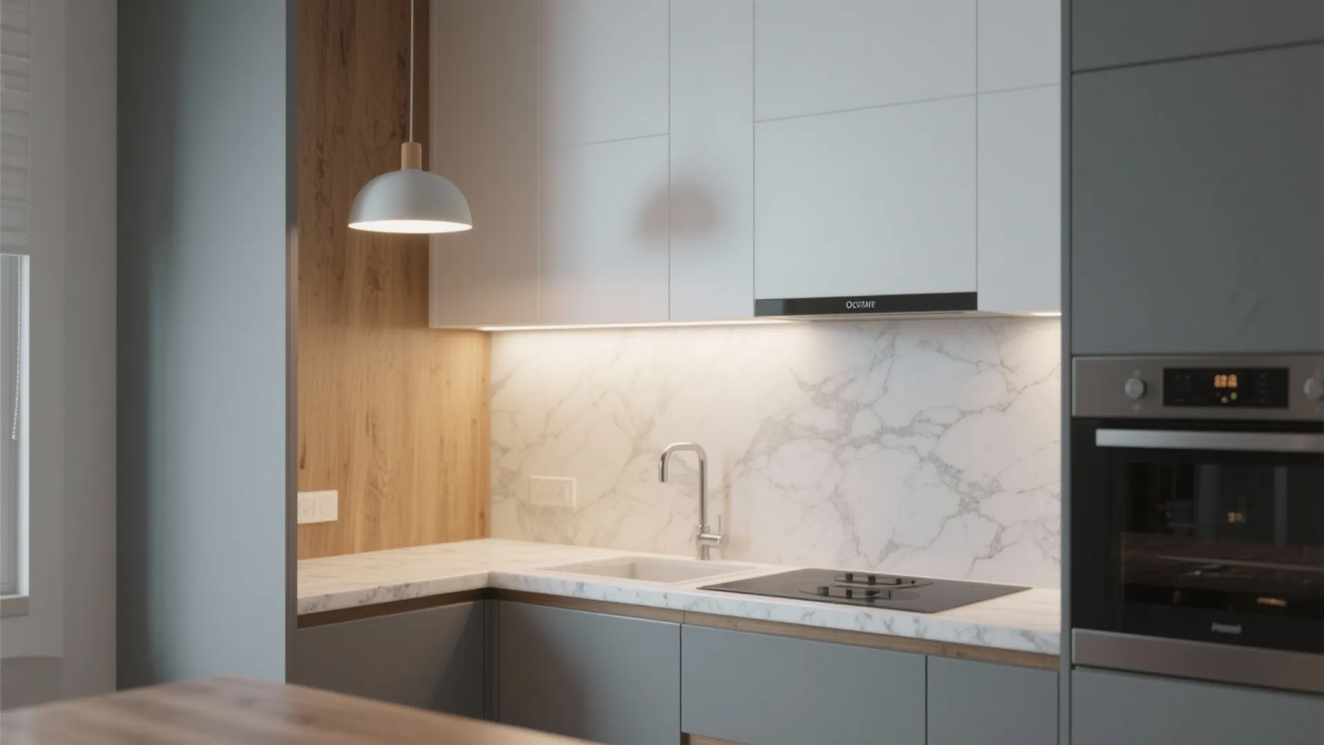 Compact kitchen with soft gray lower cabinets and white uppers, layered lighting and marble accents.