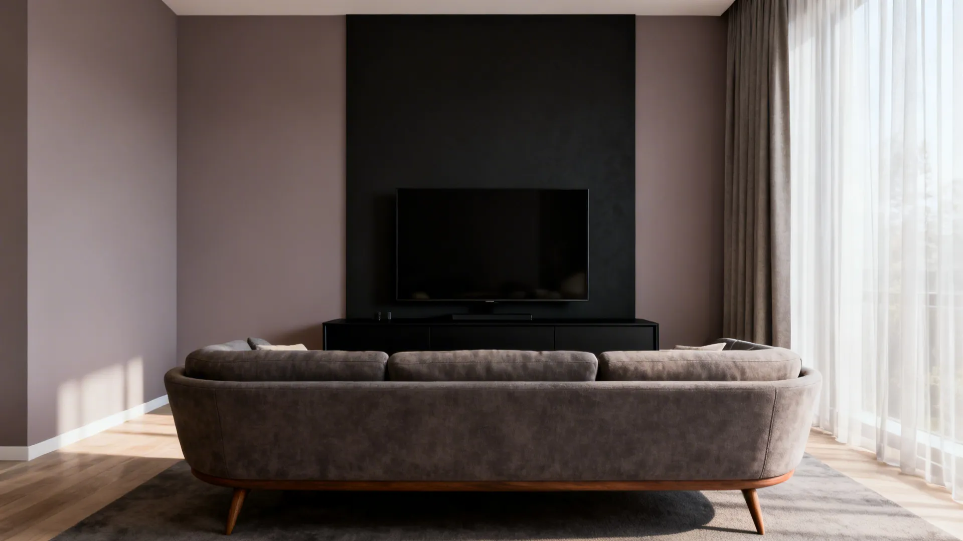 Living area with warm dove grey walls and a deep charcoal TV accent wall with a black media unit