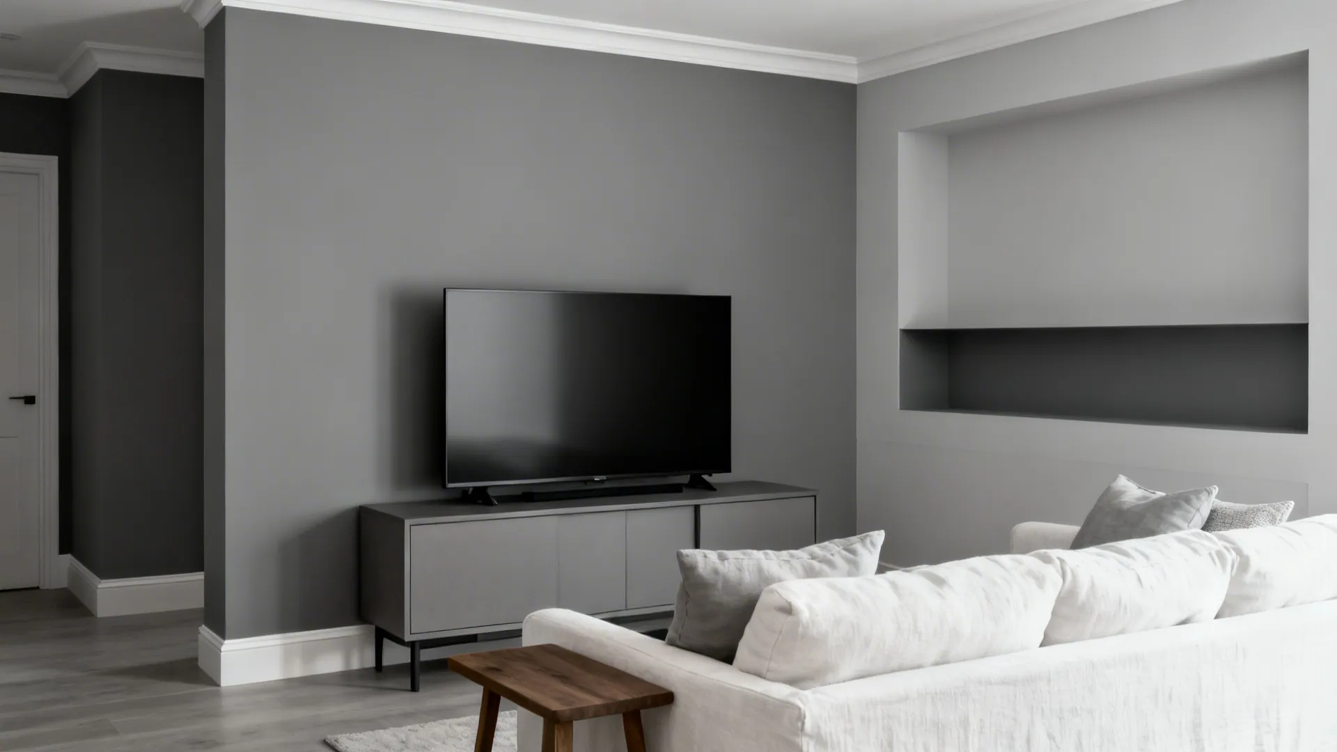 Compact living room with three gray tints creating soft monochrome layers around a TV wall.