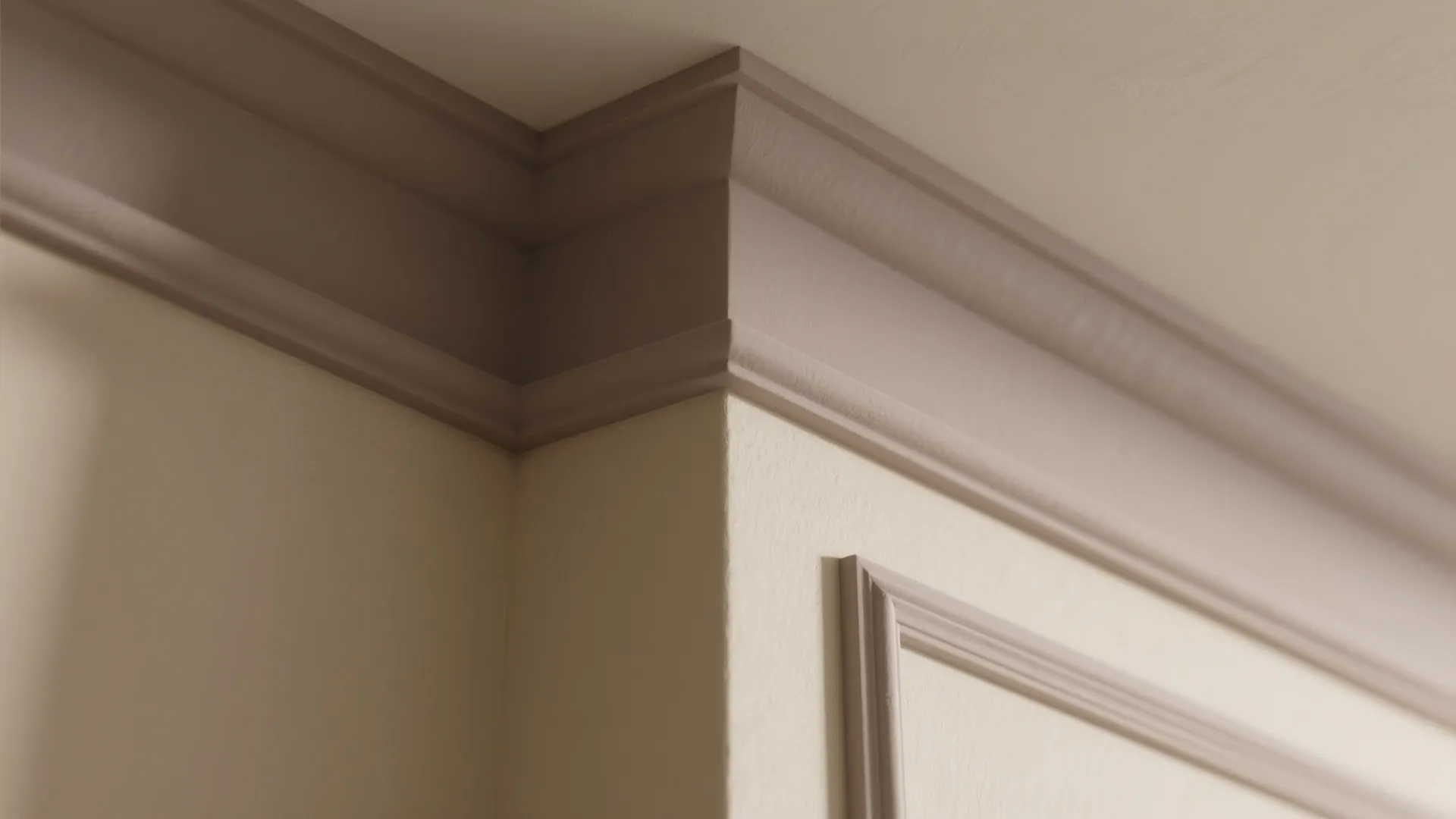 Close up of taupe wall panel and ceiling trim in a modern room with neutral paint