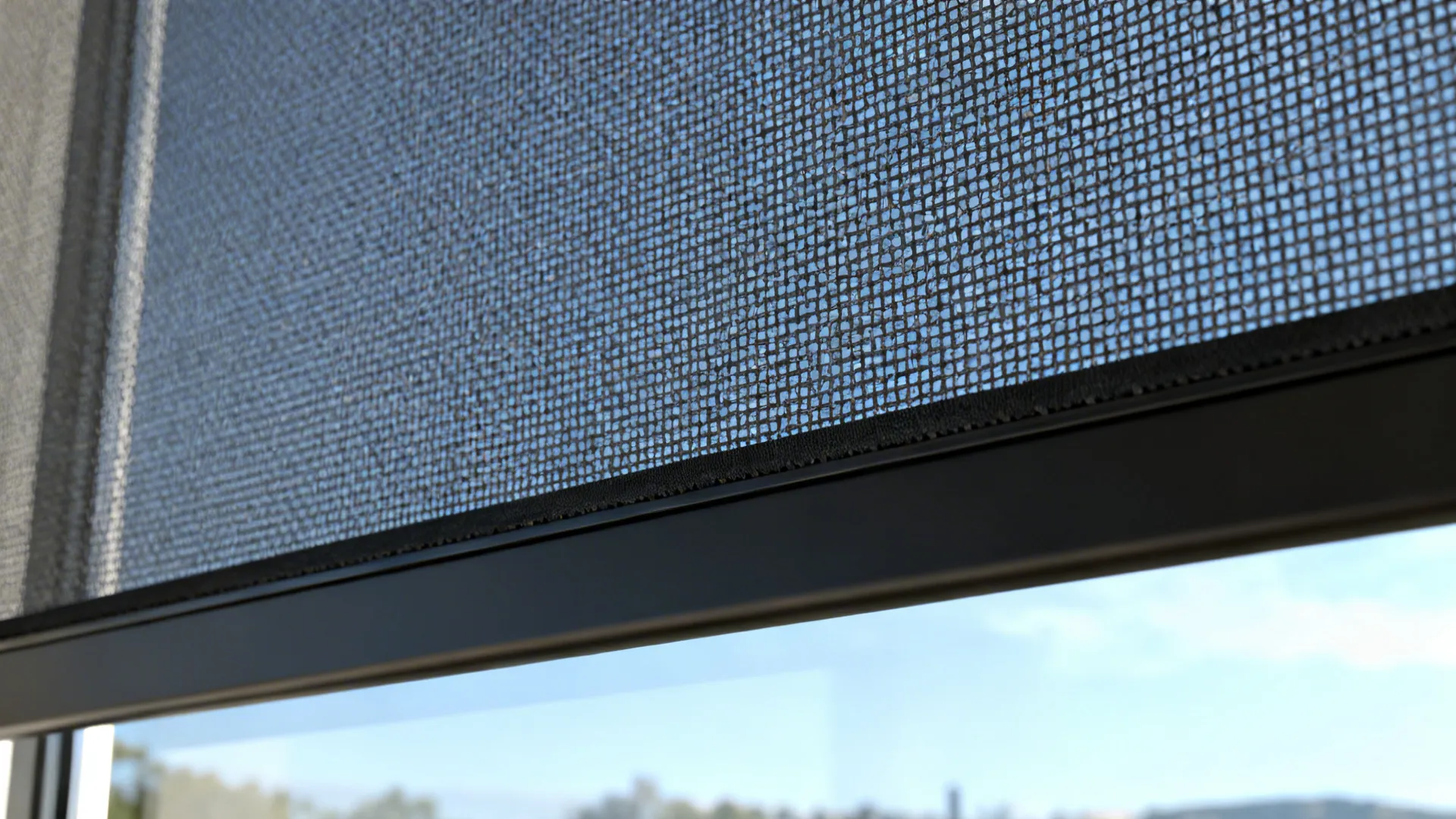 Close-up of 3% solar shade mesh with a sealed hem bar and view beyond.