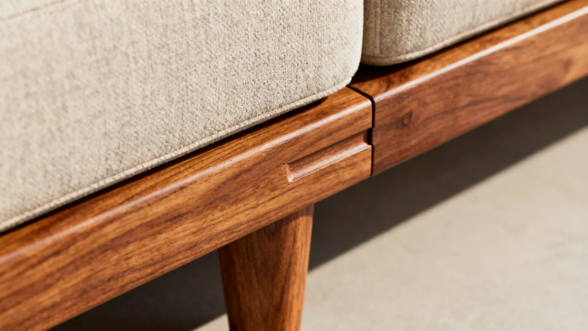 Close-up of a solid hardwood sofa frame joint showing mortise-and-tenon construction and wood grain.