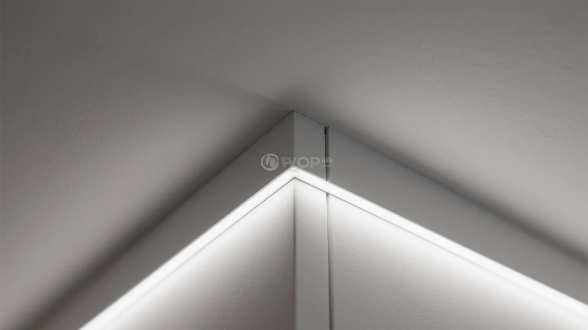 Close up shot of a bright modern linear light fixture installed in a white corner