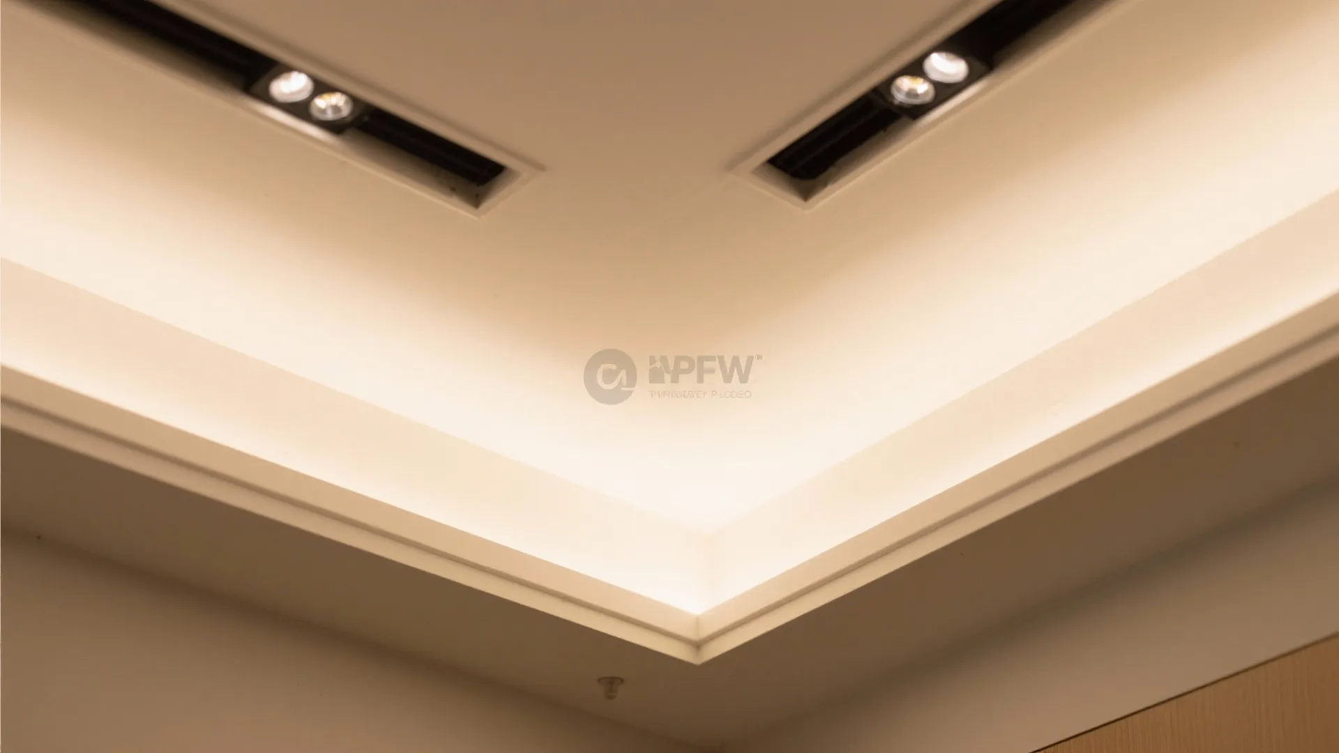 Close up view of a modern white ceiling with recessed light fixture and warm lighting