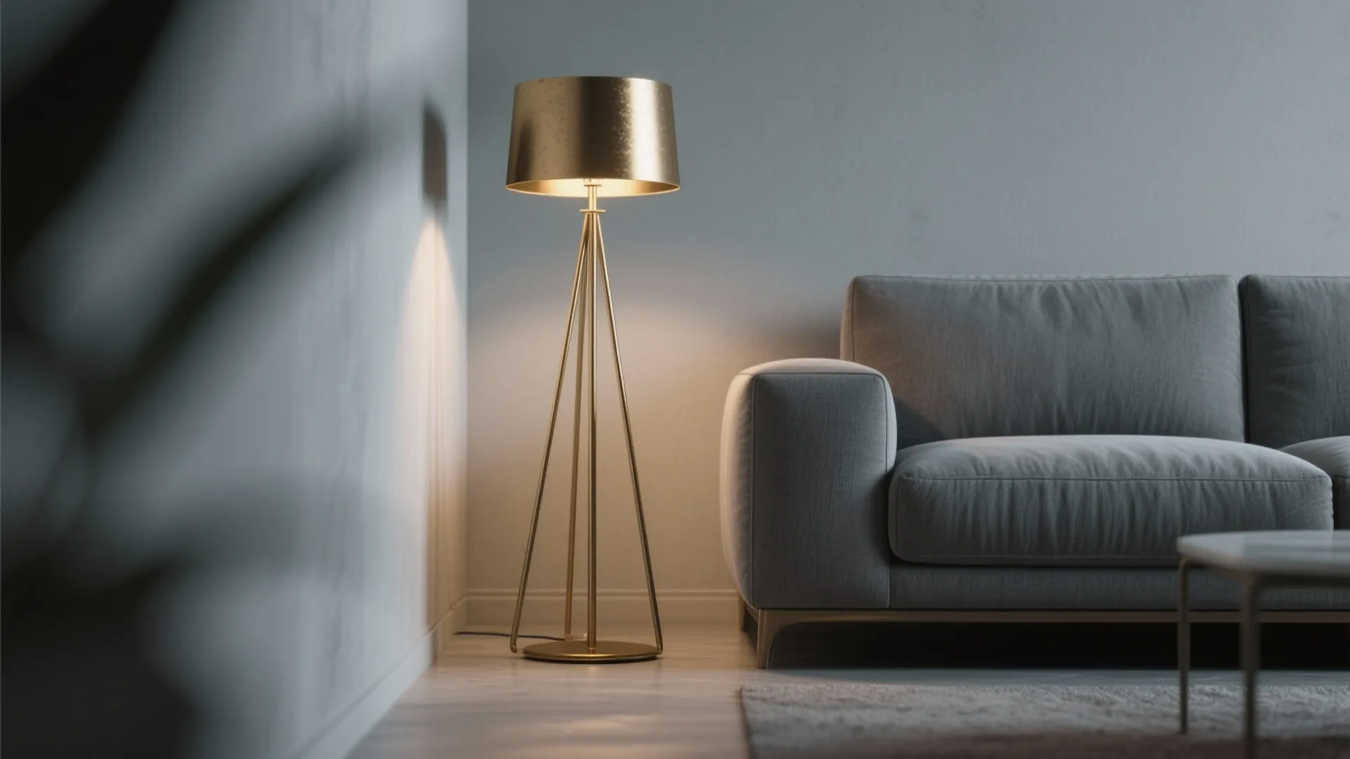 Golden floor lamp standing next to a grey fabric sofa in a minimalist living room