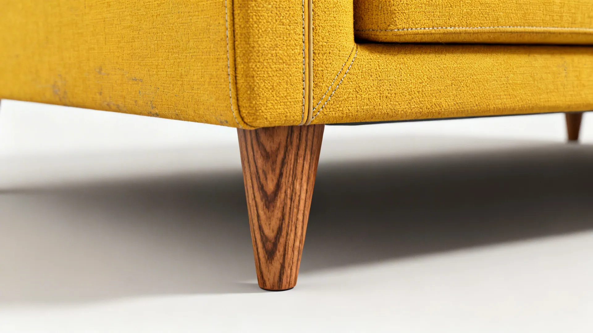 Close-up of a mid-century sofa tapered leg and performance fabric upholstery