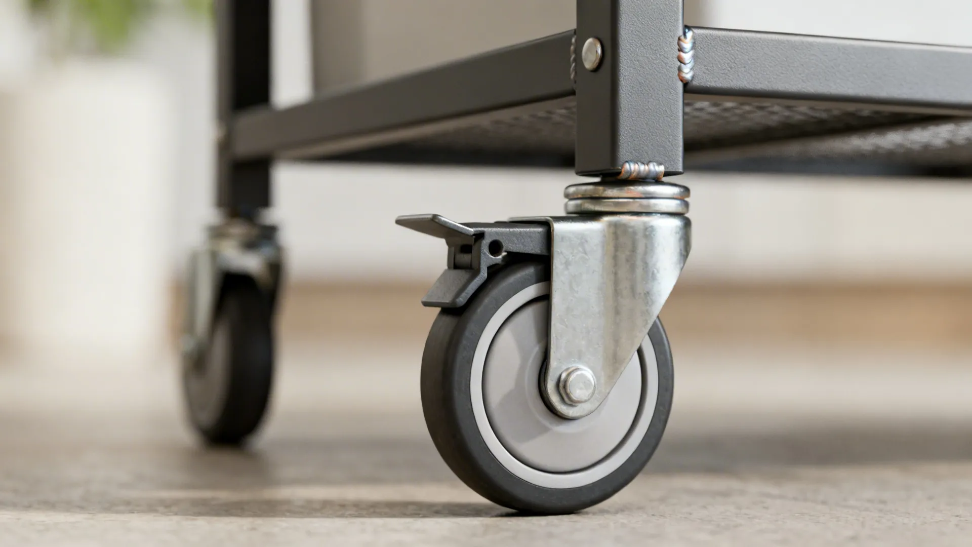 Macro of a lockable soft-tread caster on a powder-coated steel trolley.