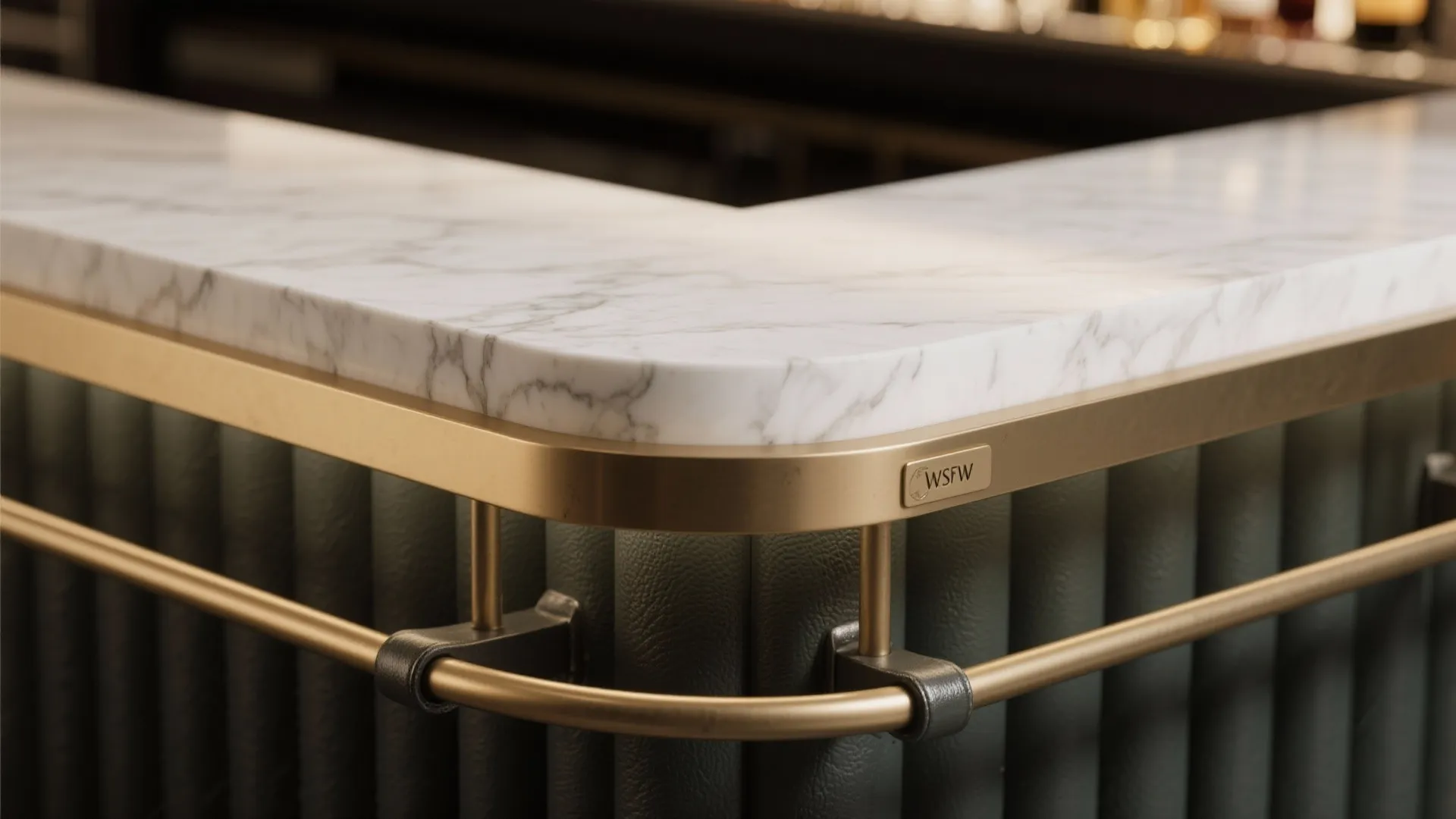 Close up of marble countertop with brass metal trim and green fluted wall panel detail