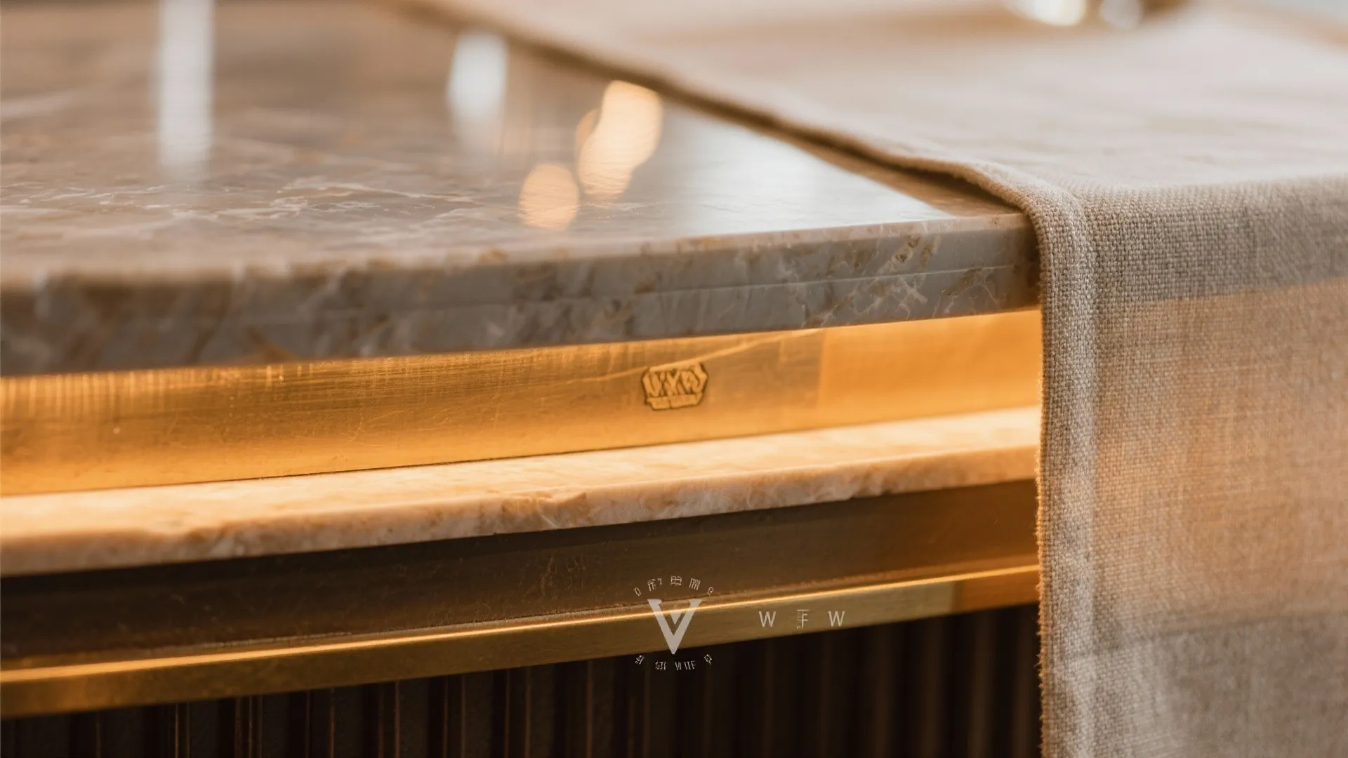 Close up of a marble stone table with brass metal edge warm light and linen