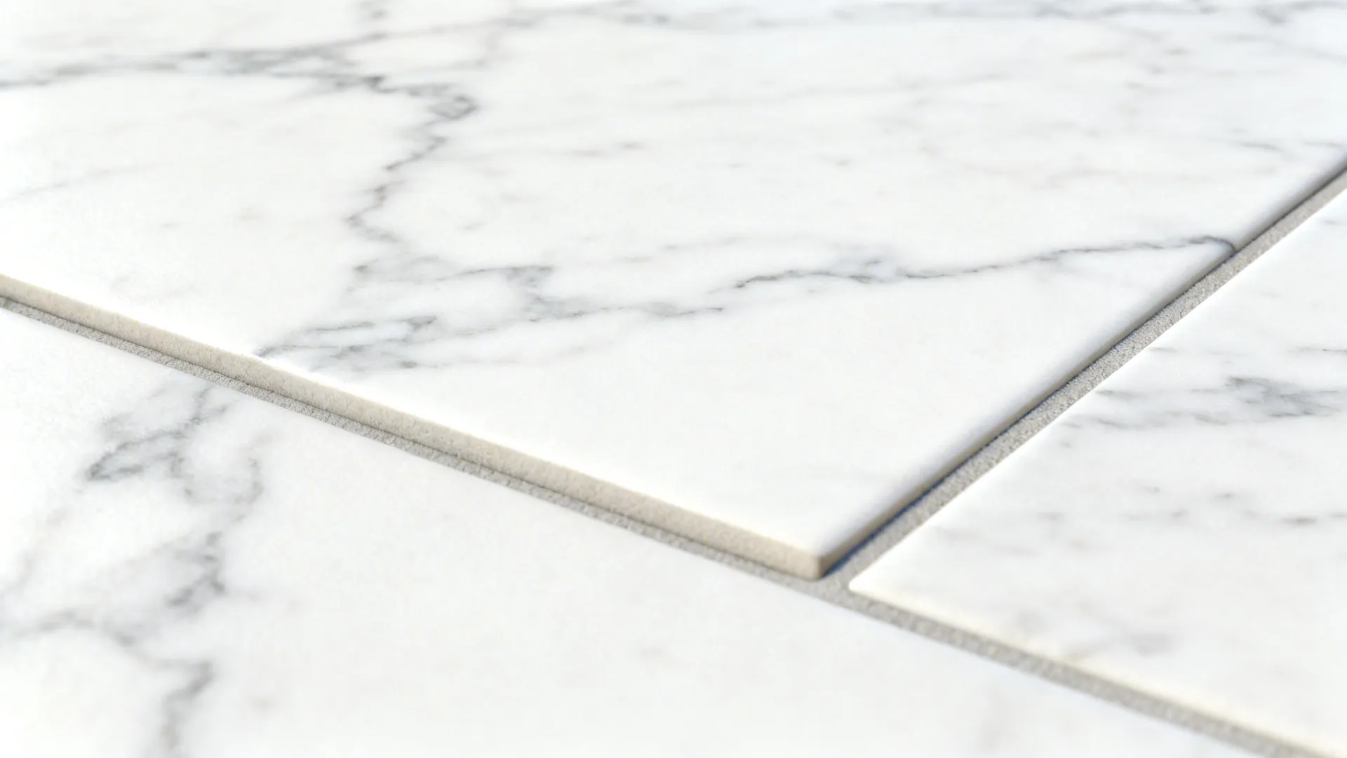 Macro of stone-look white porcelain tile showing subtle gray veining and tight grout.