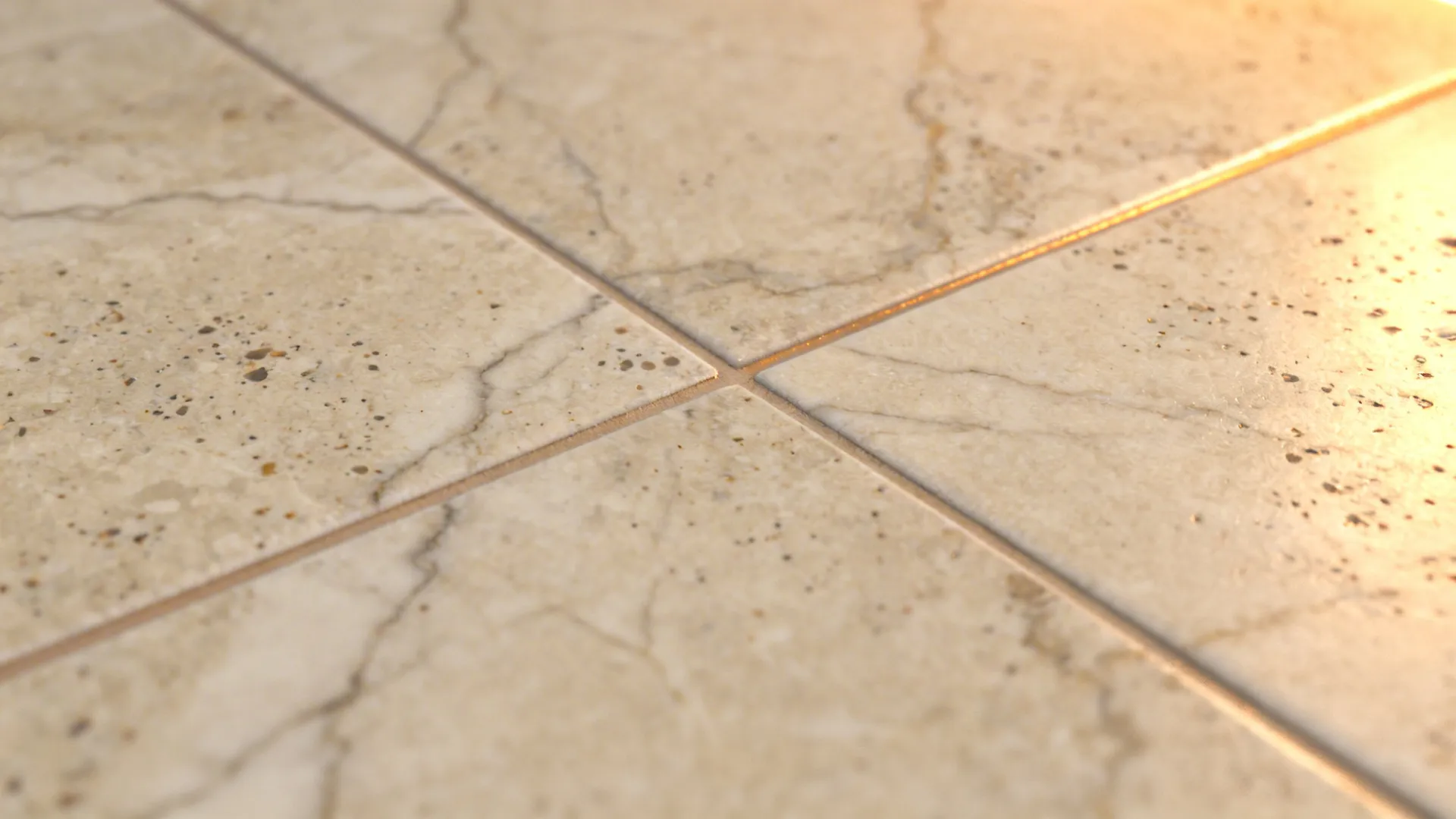 Macro view of beige stone floor tiles with visible grout lines and warm natural light