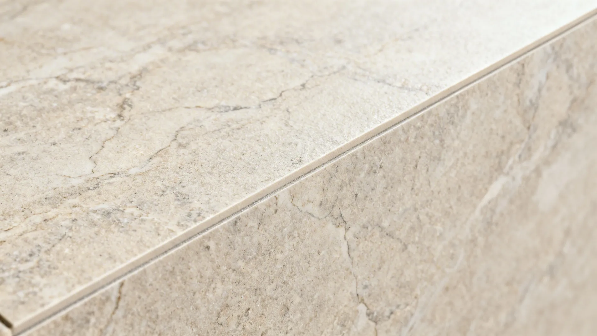 Macro of porcelain slab with fine mineral veining and matte honed surface under soft light.