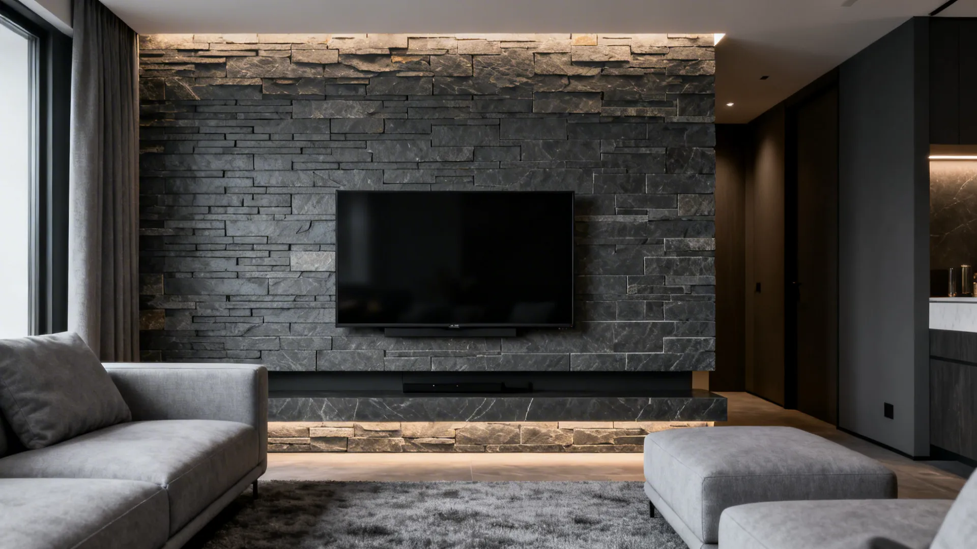 Slate-look stone accent wall behind a TV in a compact living room with light grey furnishings