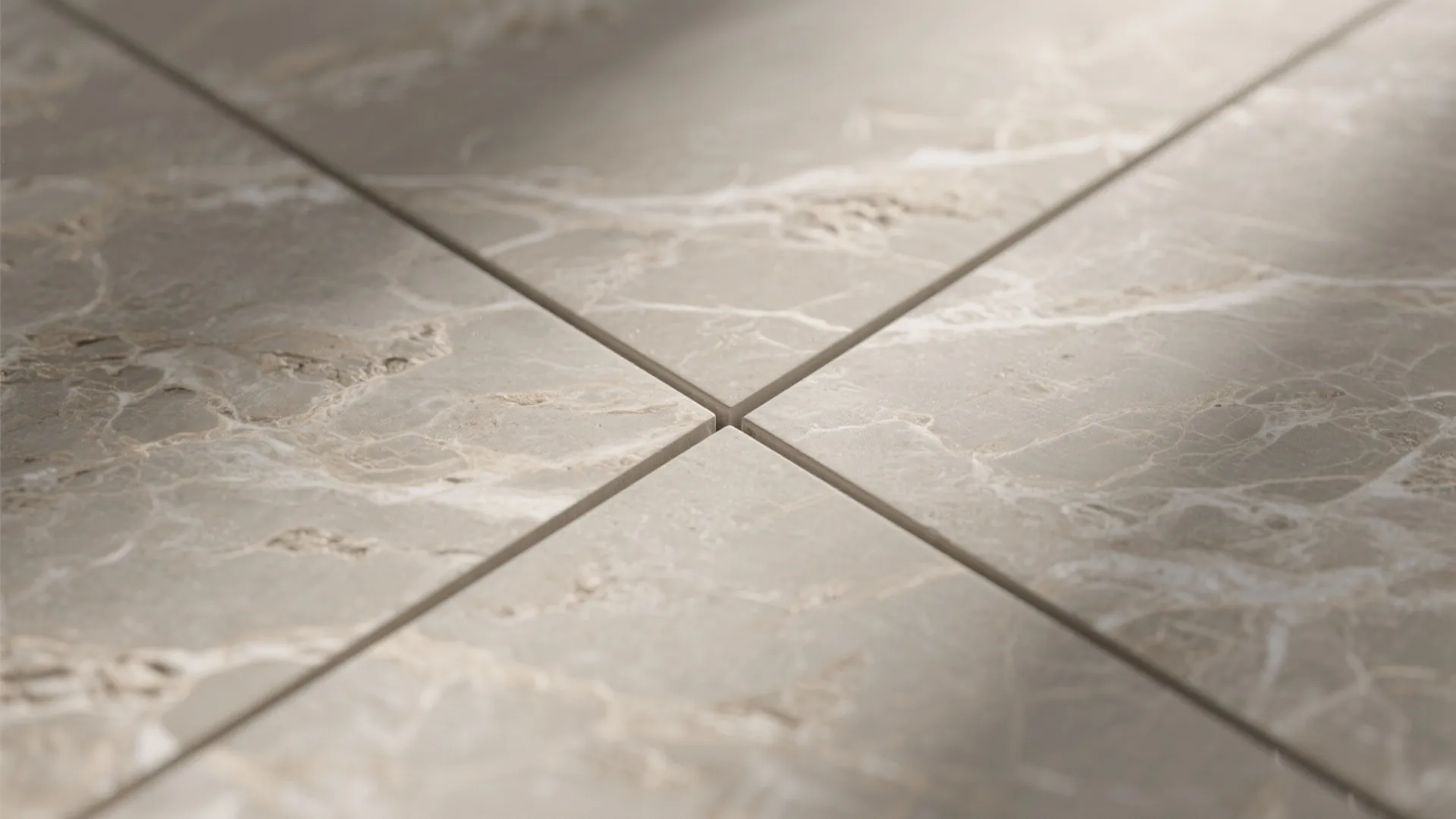 Macro of warm greige stone-effect porcelain with soft veining and matte texture.