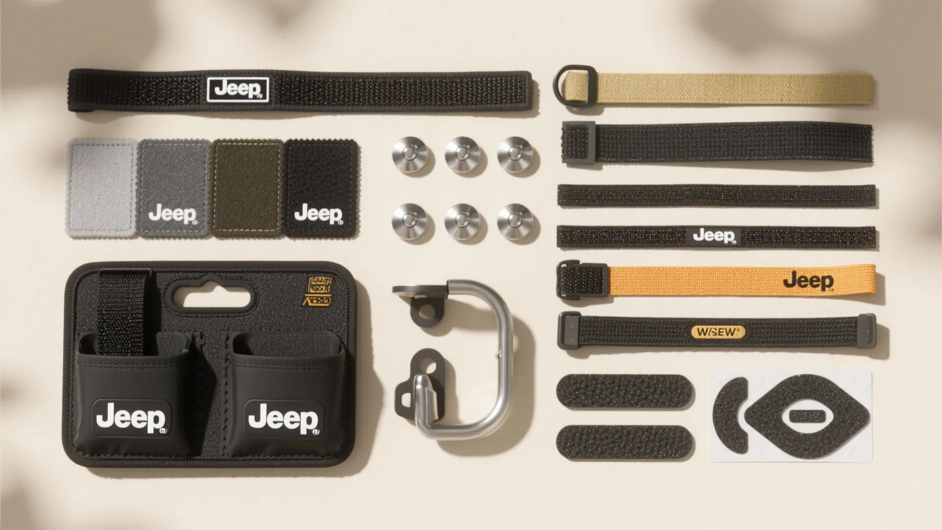 Collection of black and tan storage straps patches and metal mounting hardware on beige background