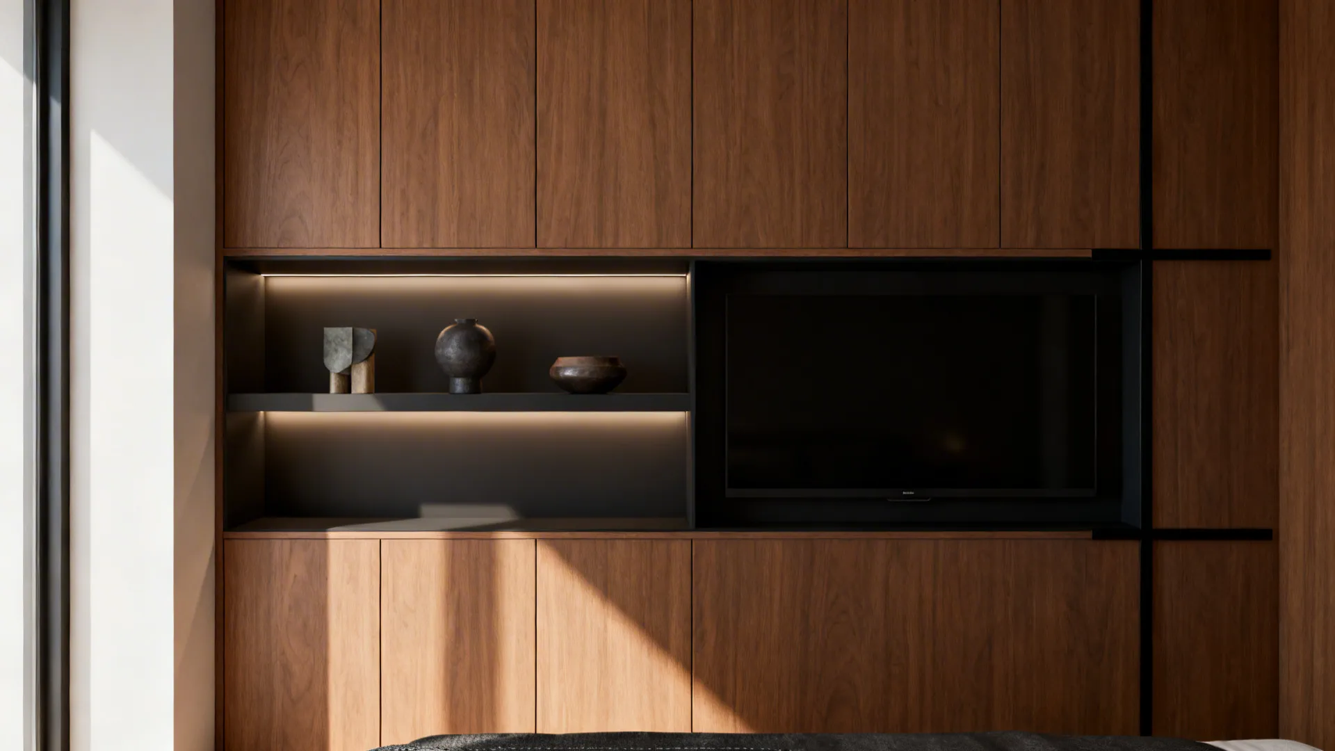 Minimalist oak storage wall with open shelves and integrated TV in a small bachelor room.