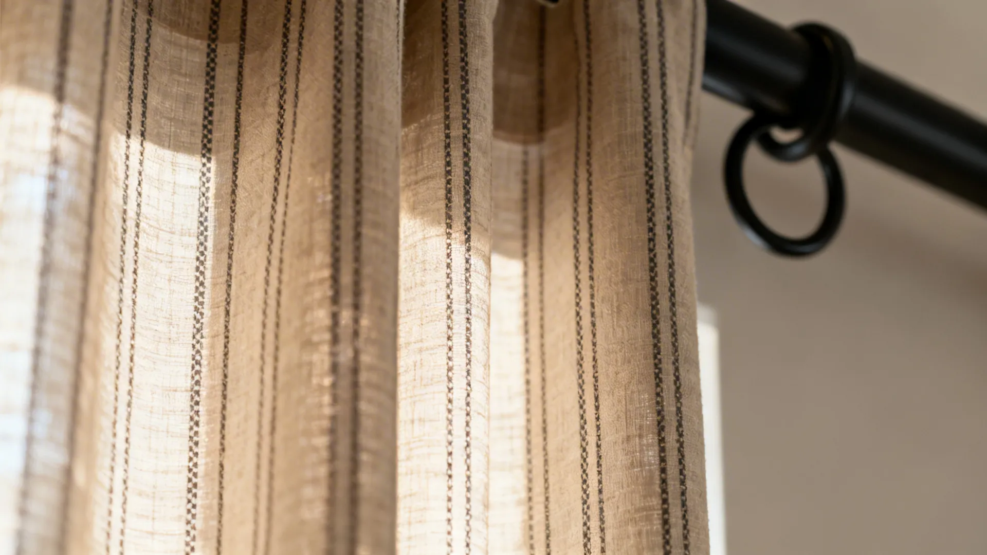 Close-up of vertical stripe and micro-print curtain fabric in warm neutrals.