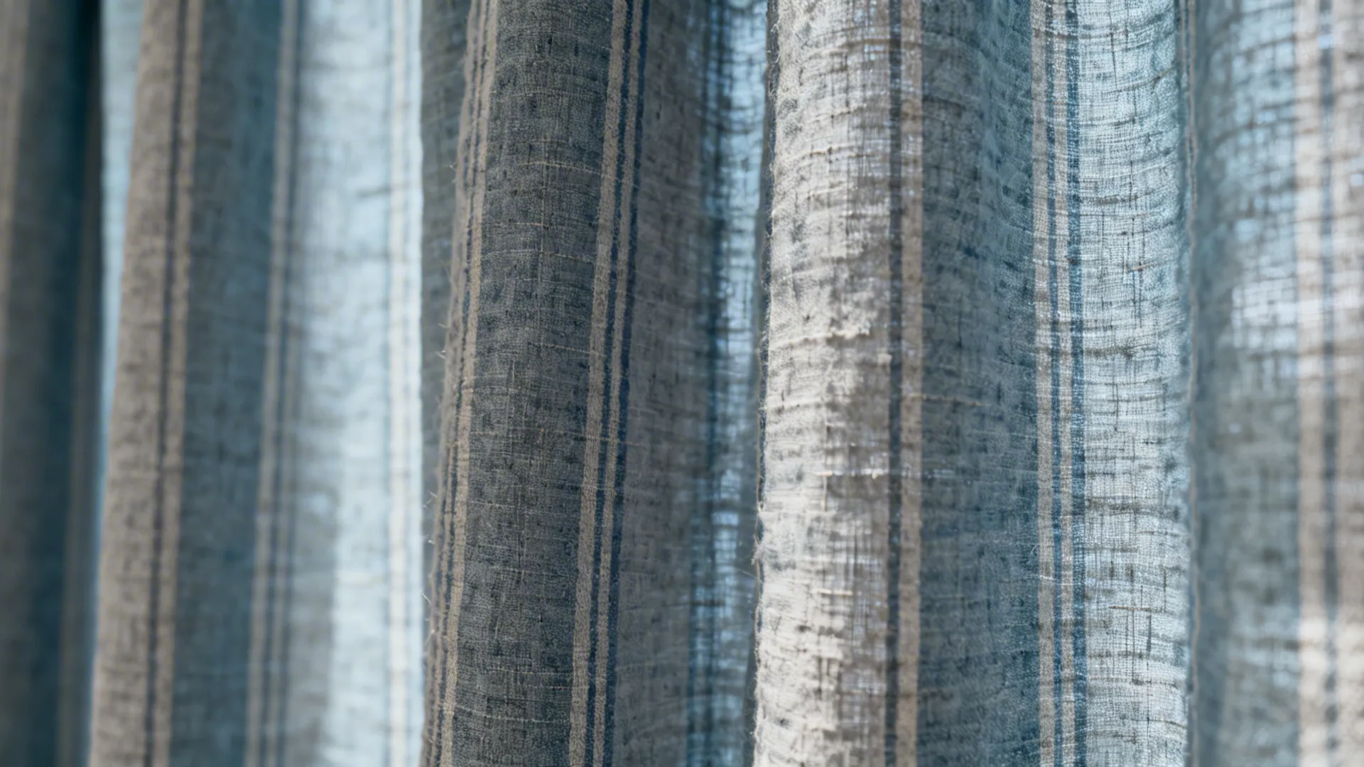 Close-up of dusty blue and soft grey striped linen-blend curtain with visible texture.