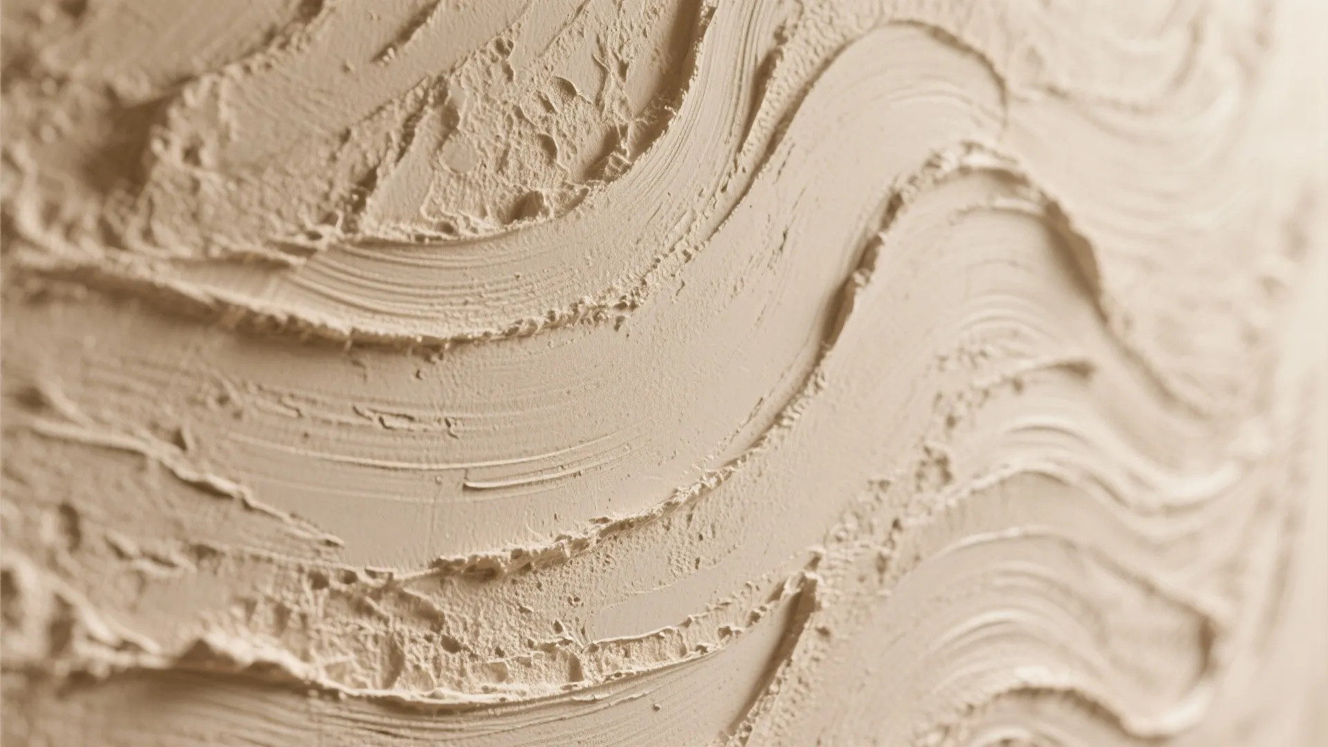 Close up view of beige textured wall plaster with wavy patterns and rough surface finish