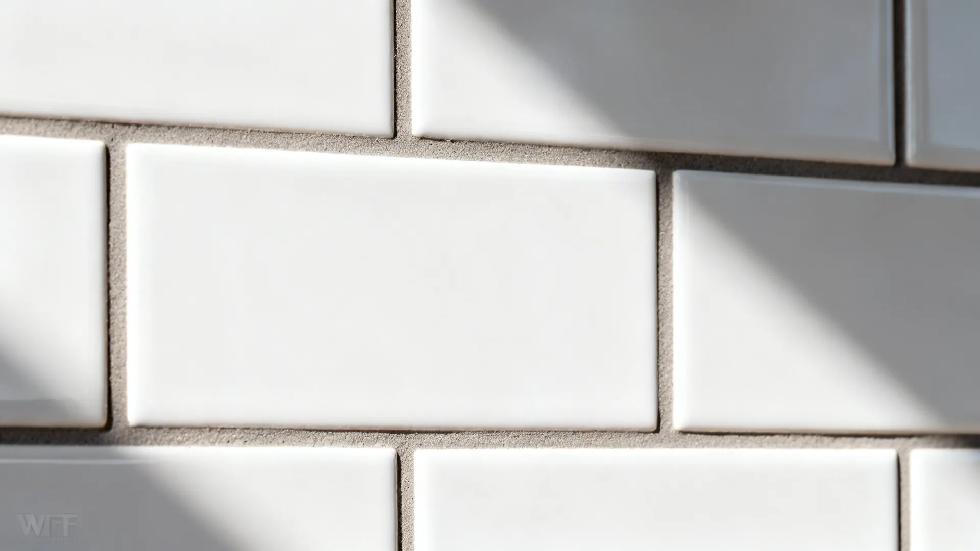 Macro of matte white subway tiles with precise 1/16-inch warm gray grout lines.