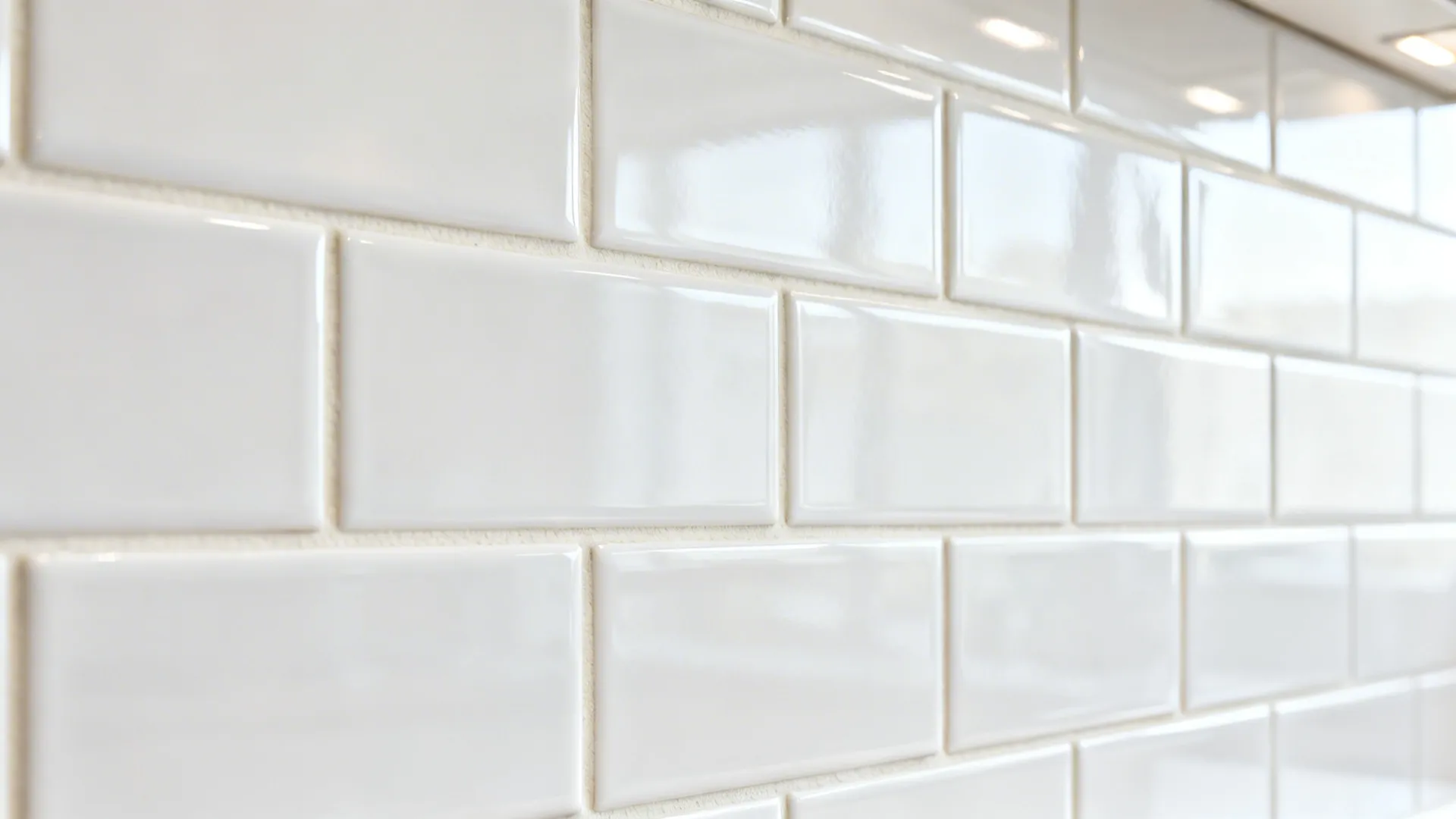 Macro of glossy subway tiles in a tight grid with thin off-white grout and clean reflections.