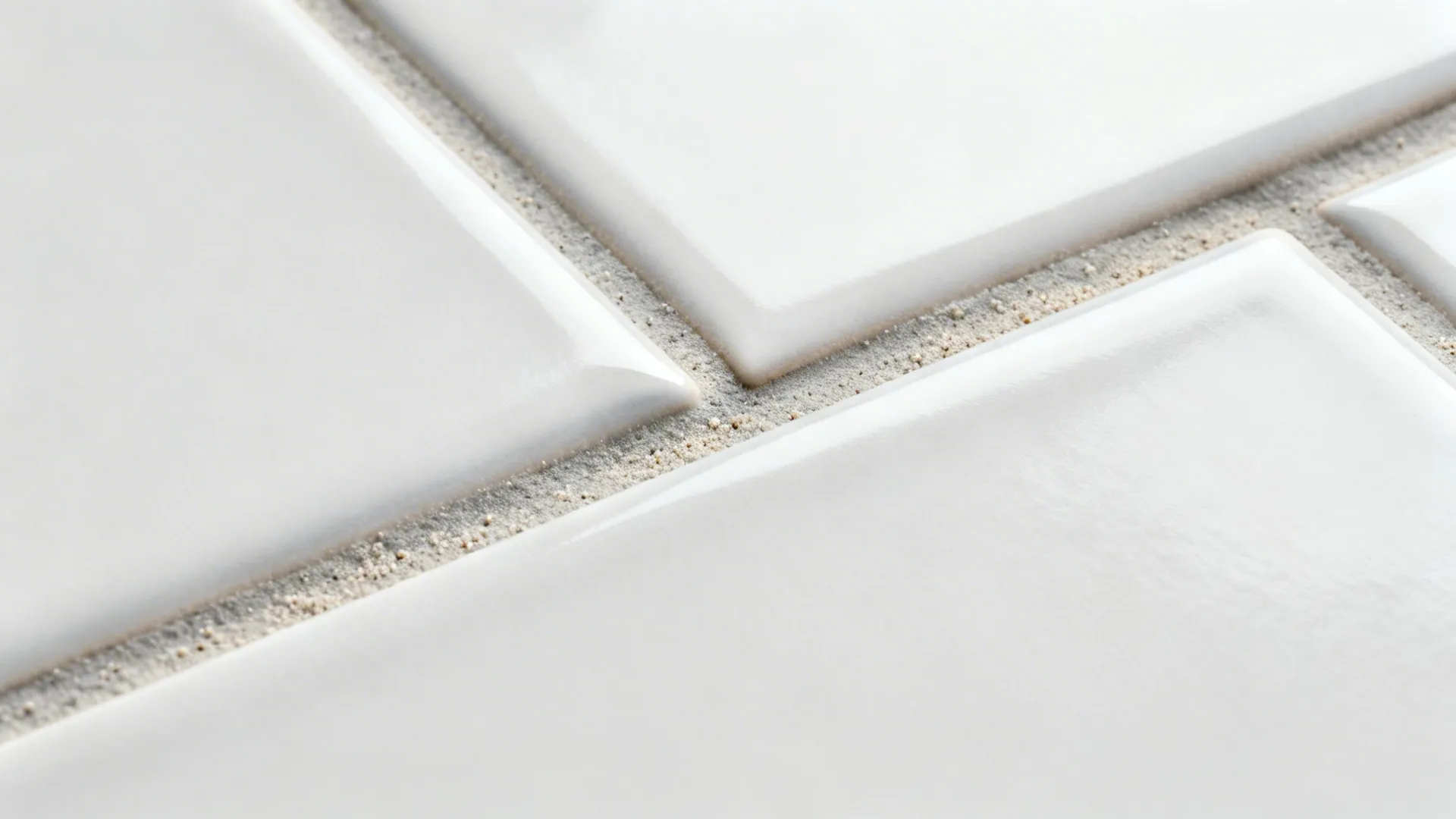 Macro of matte elongated subway tiles with light gray grout and flat non-beveled edges.