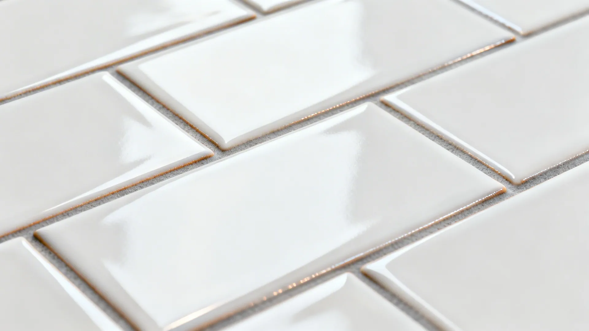 Close-up of glossy white subway tiles with micro-beveled edges and warm gray grout.