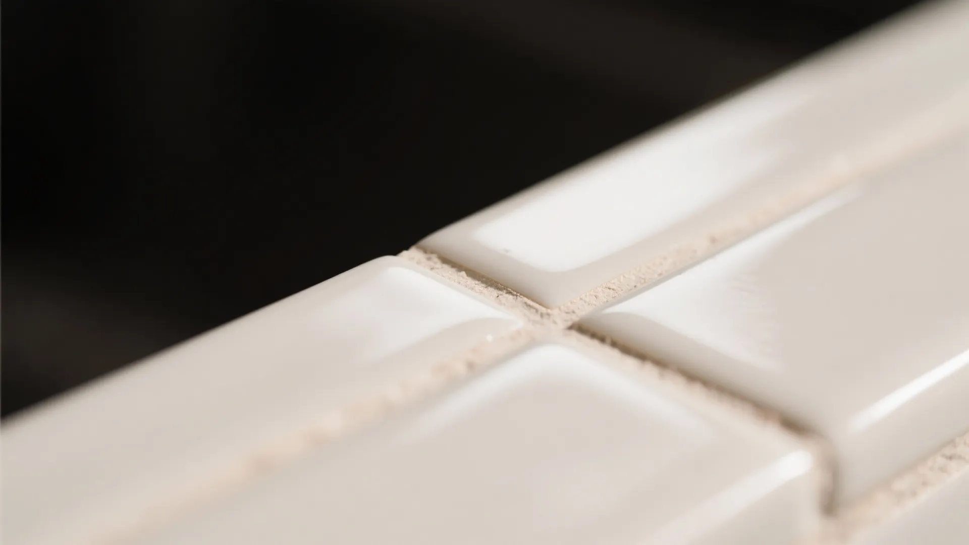 Macro view of white wall tiles showing clean grout lines and smooth glossy surface finish