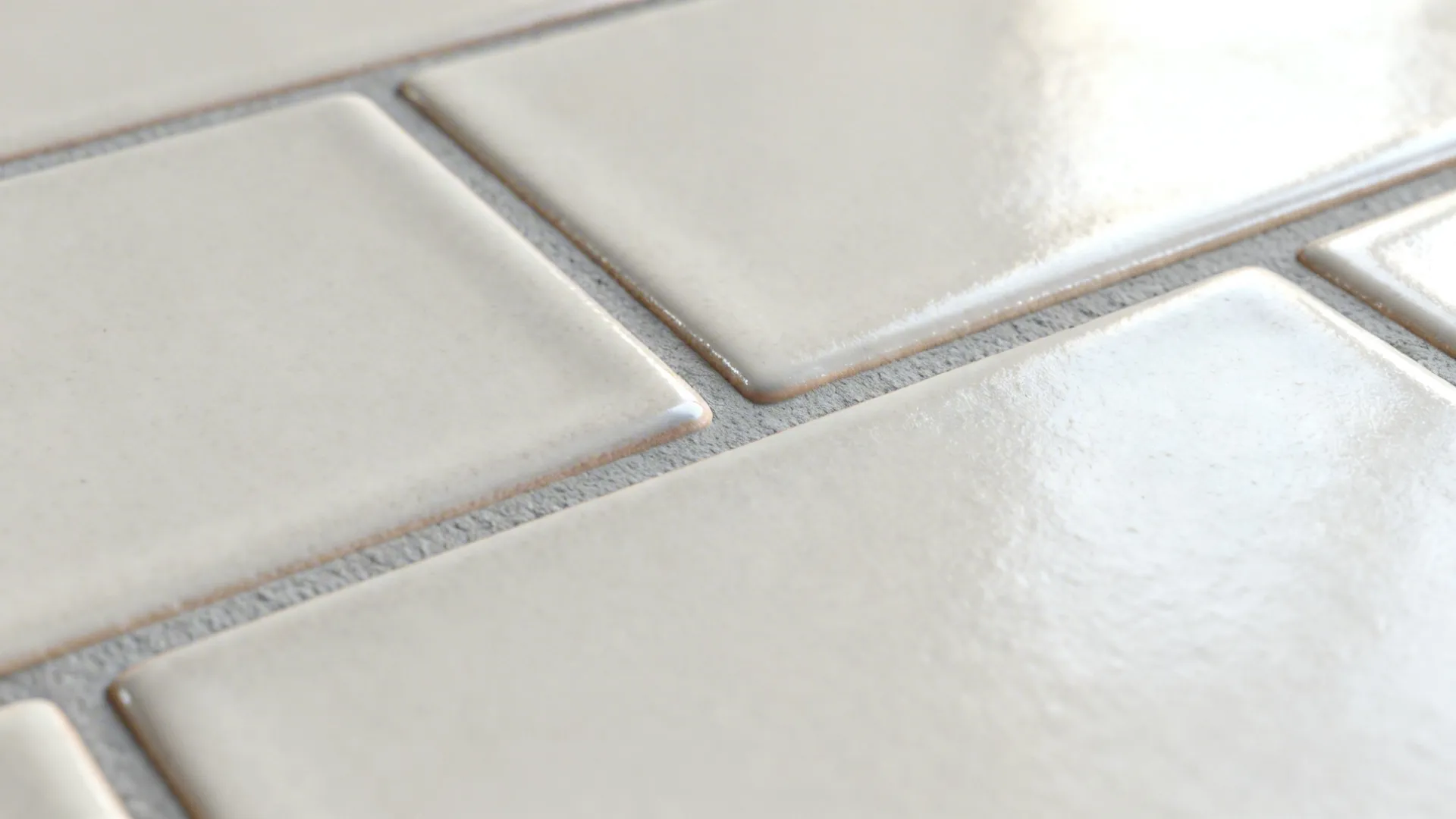 Macro of warm grey-white subway tile showing soft-grain glaze and light grey grout.