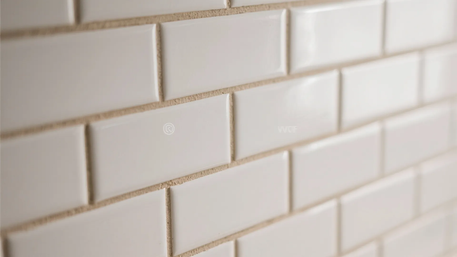 Close up of white wall tiles with beige grout lines in a bright clean bathroom