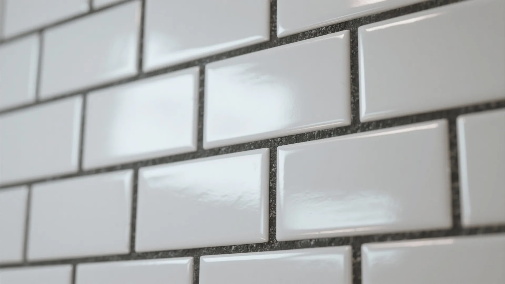 Close-up of glossy white subway tiles with dark charcoal grout lines