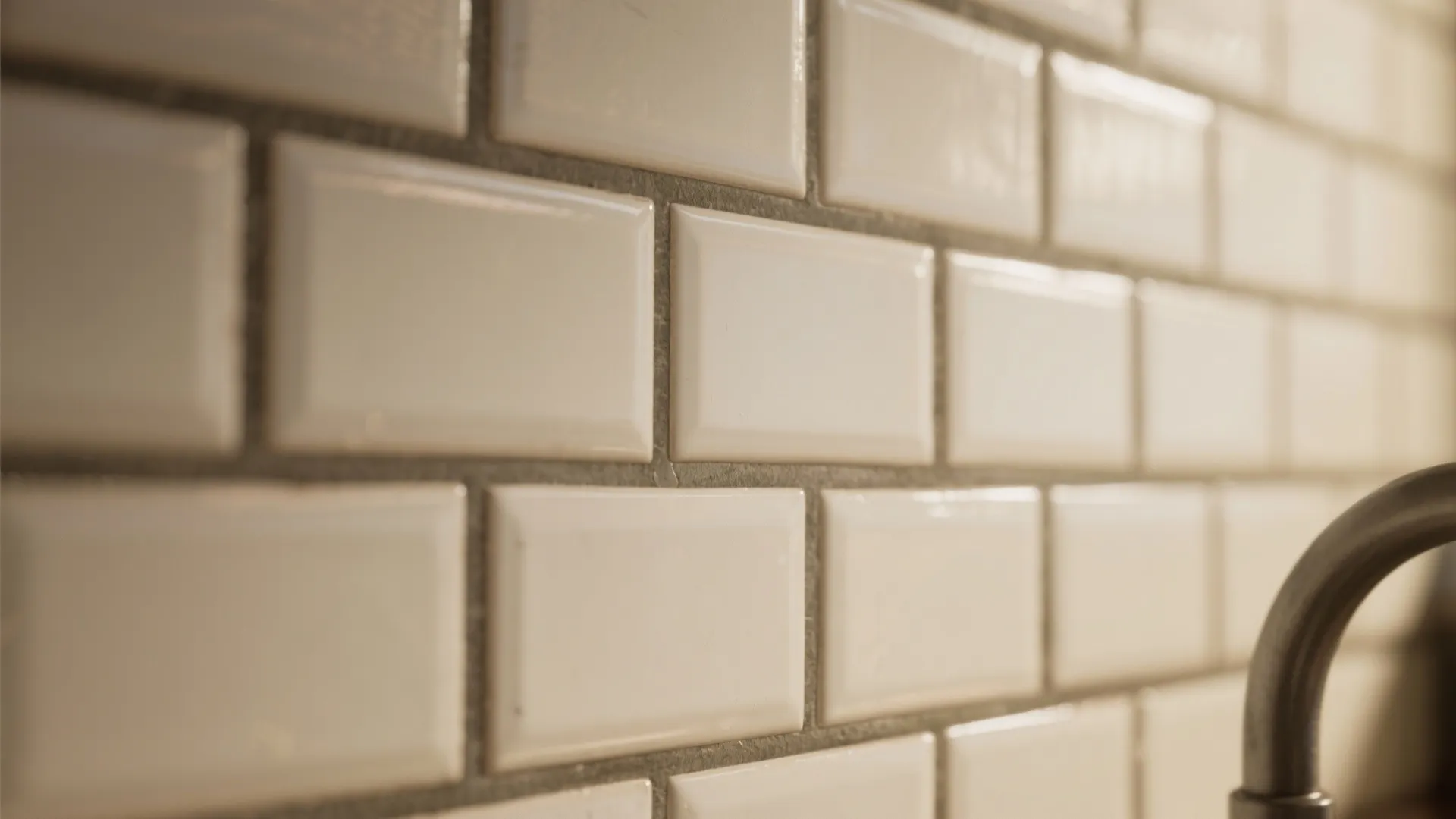 Close up view of white rectangular wall tiles with dark grout lines in a kitchen