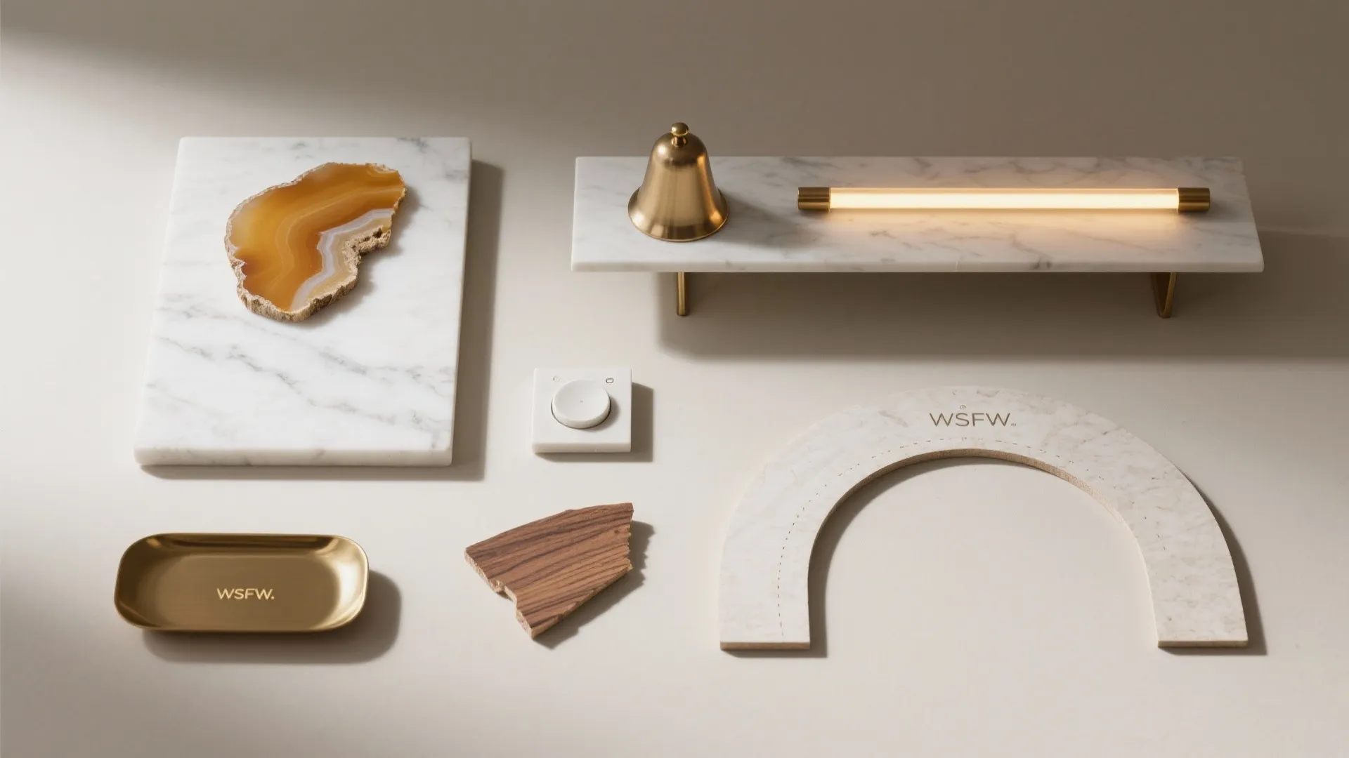 Flat lay of marble, onyx, brass, warm LED, wood veneer, and a small brass tray.