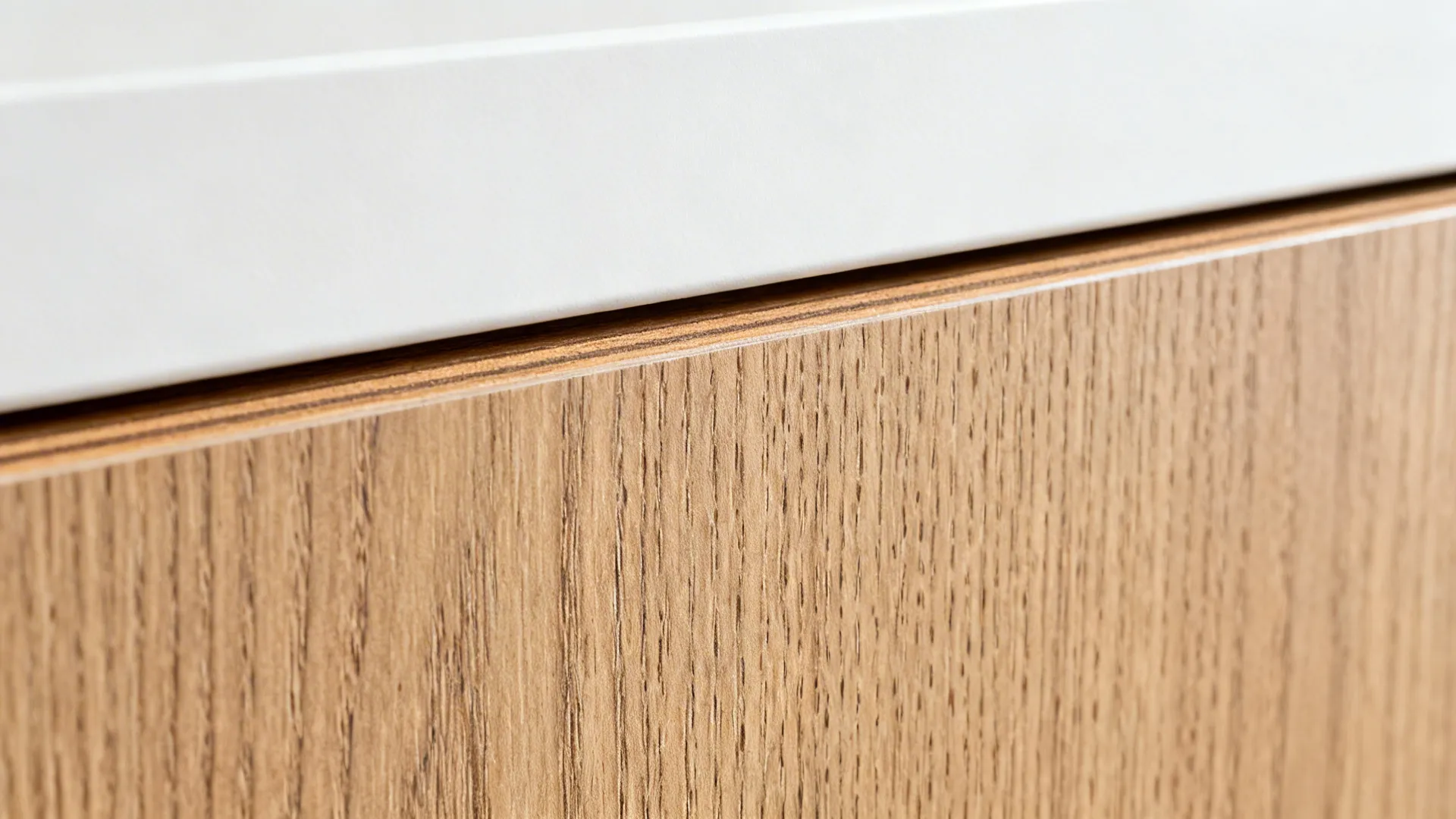 Macro of synchronized pore wood-look laminate alongside a matte white door edge