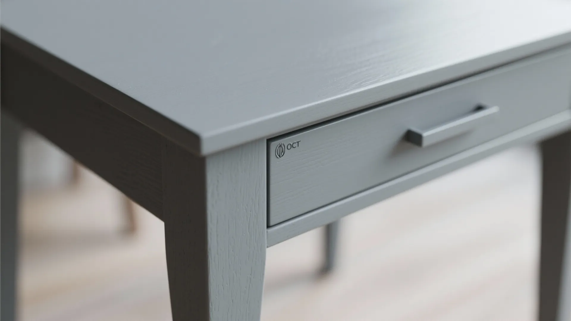 Close-up of a grey painted table edge showing matte finish and wipe-clean surface