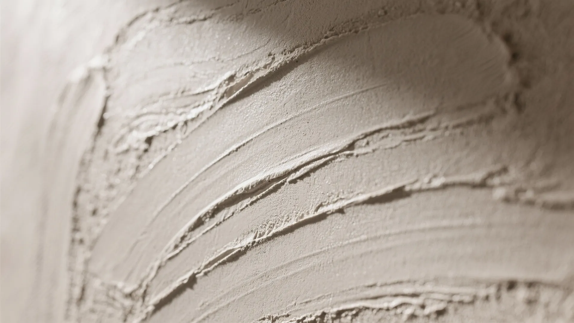 Close up of textured plaster wall finish showing detailed brush strokes in a light color
