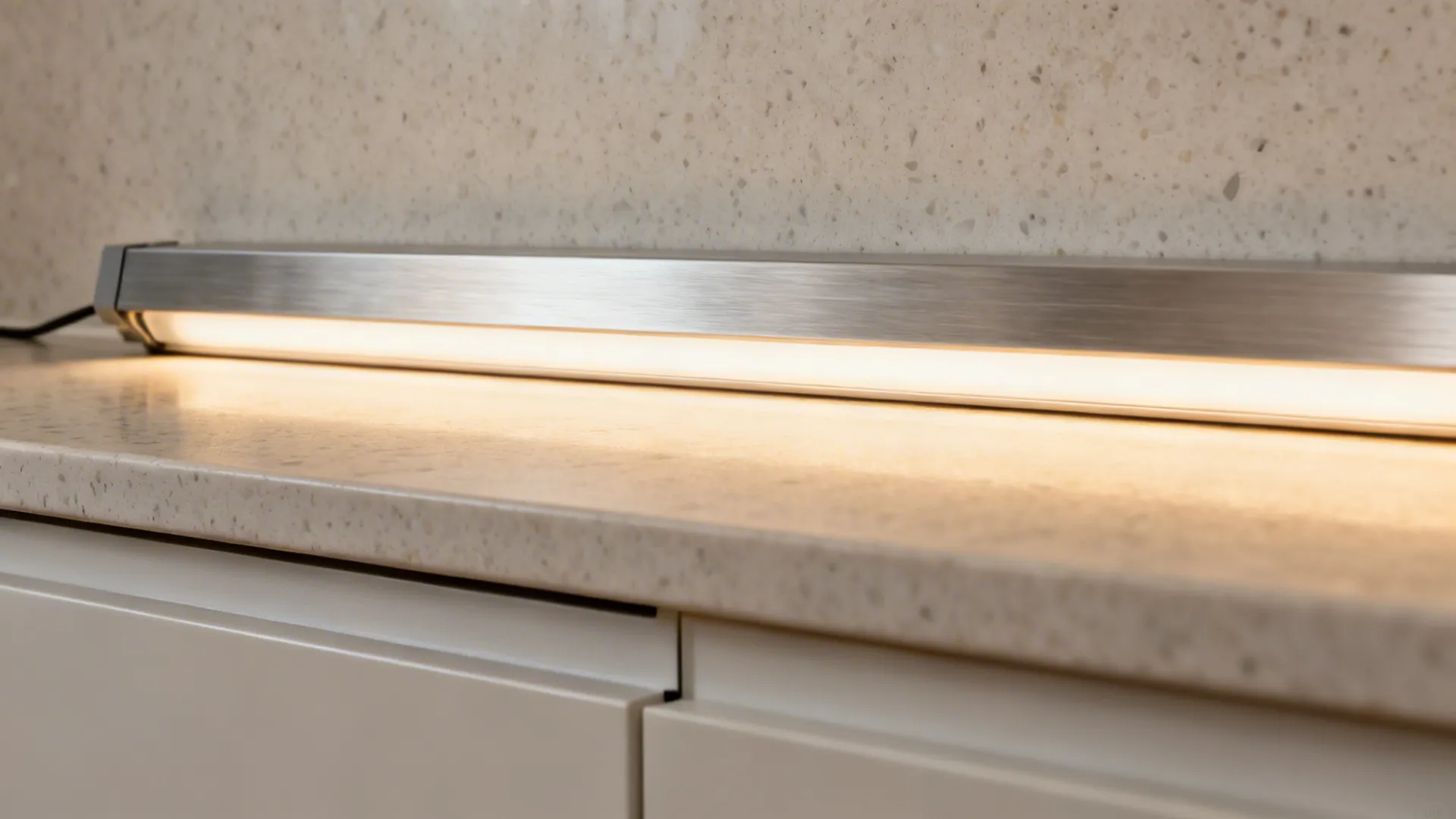 Close-up of diffused under-cabinet LED strip in aluminum channel providing even task light.