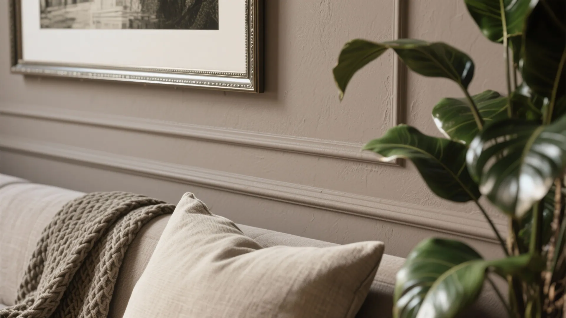 Close up of beige textured wall panel with picture frame and pillow on a cozy sofa