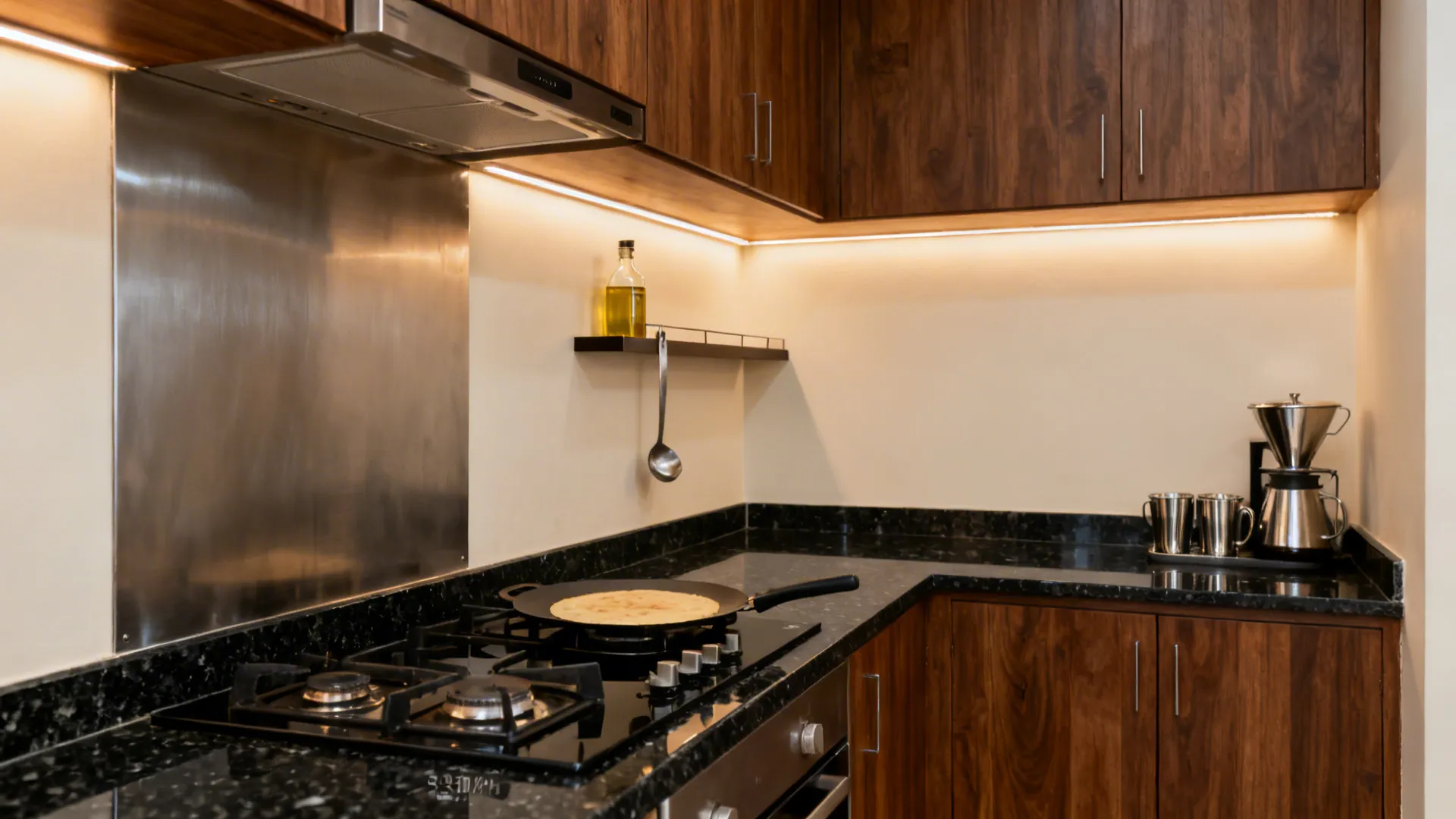 L-shaped kitchen with a dedicated tawa station in black granite and brushed steel.