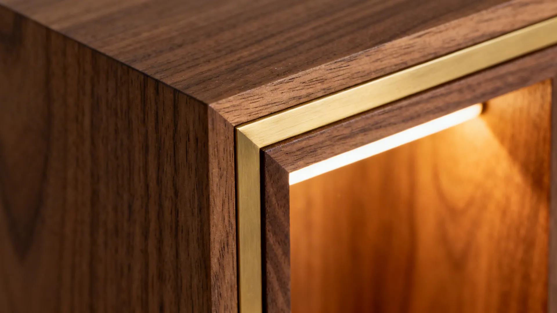 Close-up of quarter-sawn teak frame with a brushed brass inlay and warm LED glow.