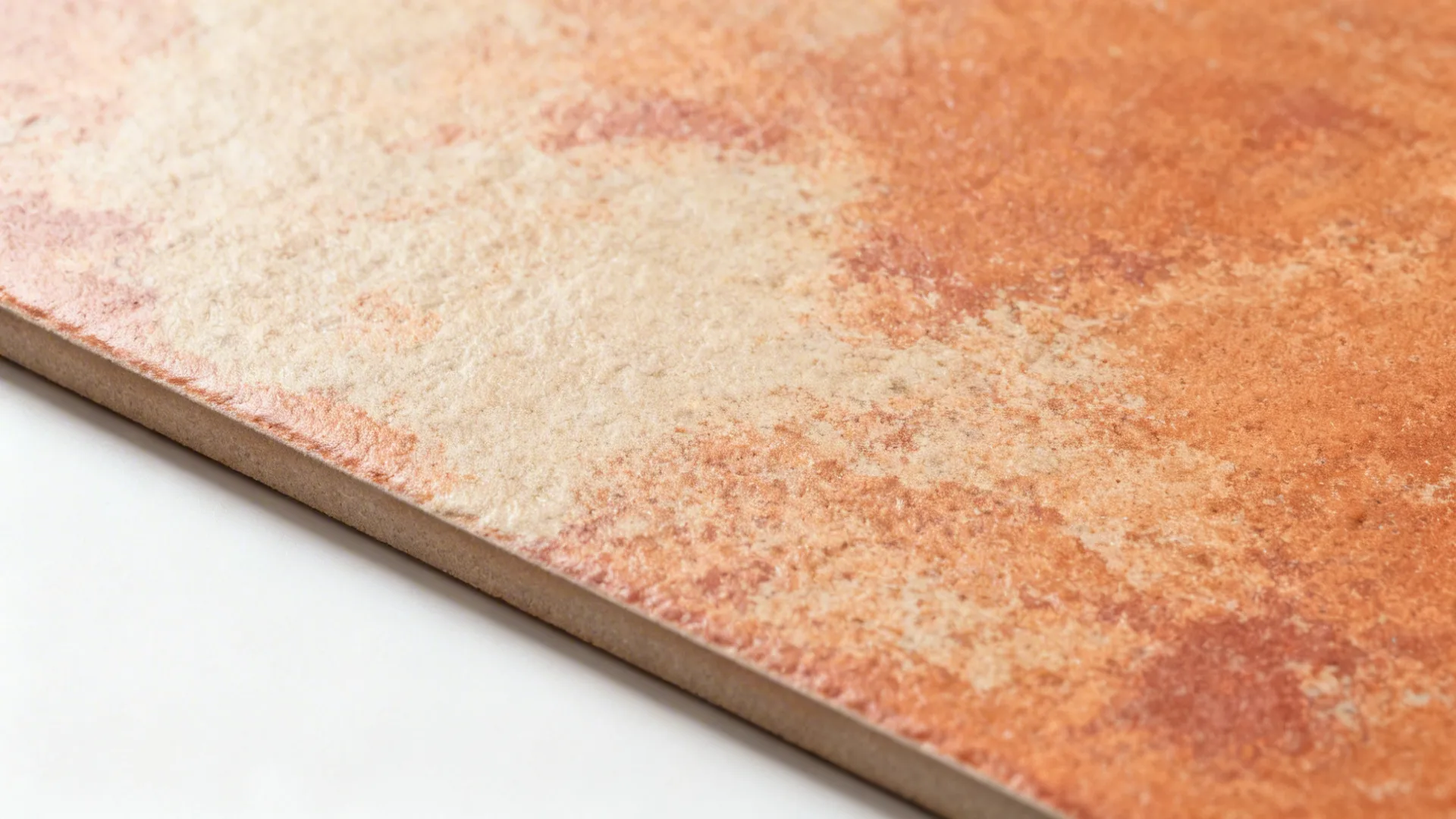 Close up of a single square orange tile with a textured surface on white background surface