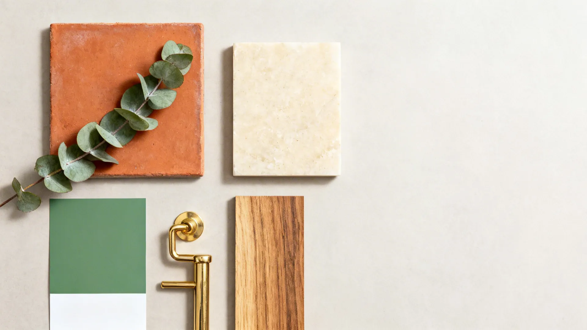 Flat lay of terracotta tile, eucalyptus green, creamy quartz, oak, and brass samples.