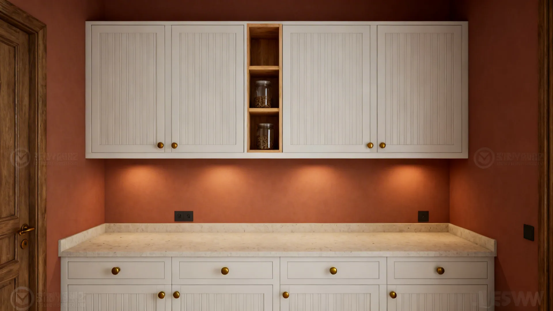 White kitchen cabinets with gold handles against terracotta walls and warm under cabinet light fixtures