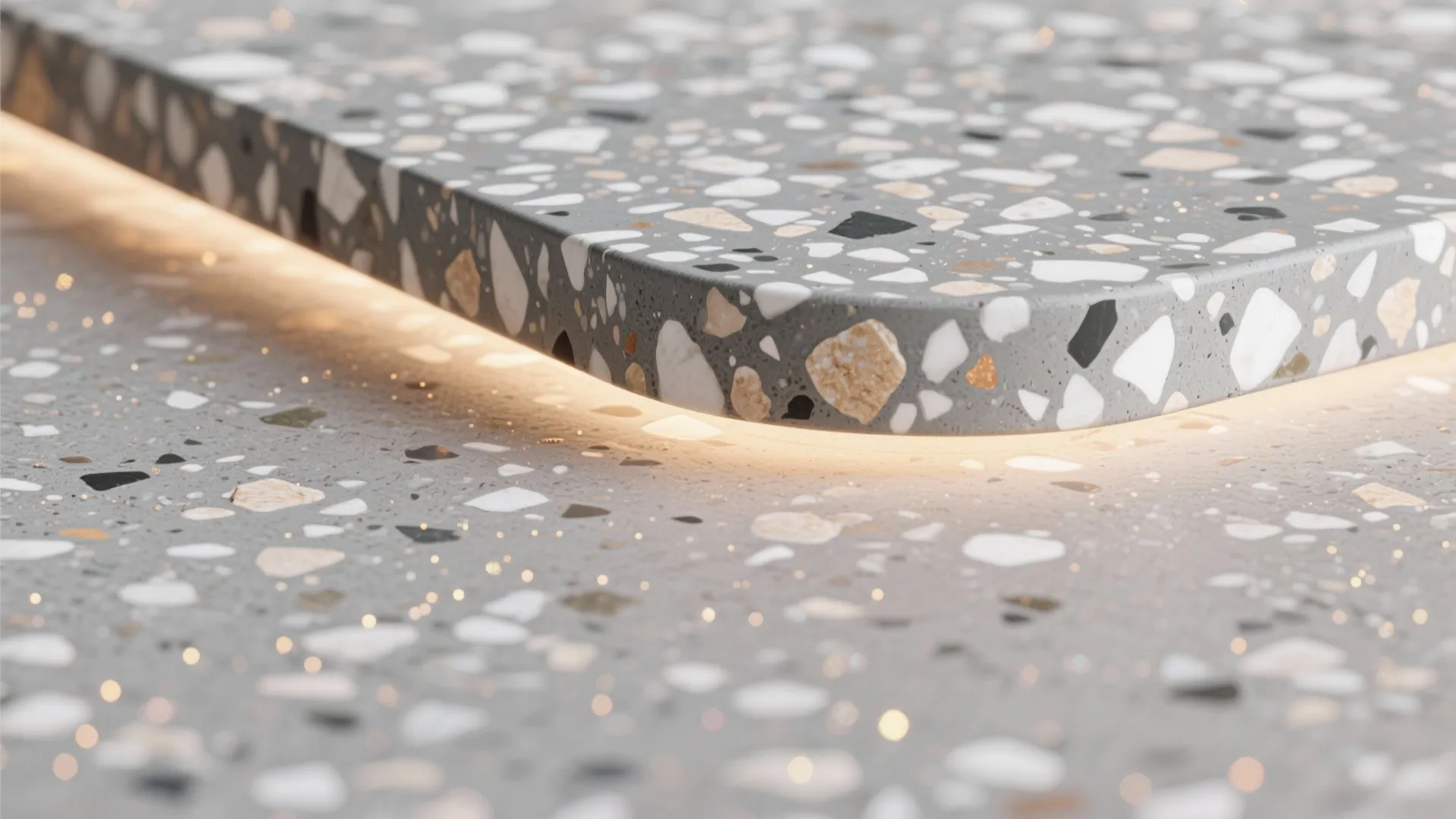 Close up of a grey terrazzo countertop with colorful stone chips and integrated warm light