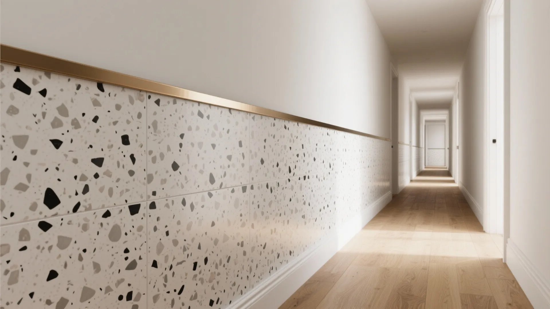 Modern long hallway with speckled wall tiles finished with a gold metal decorative trim piece